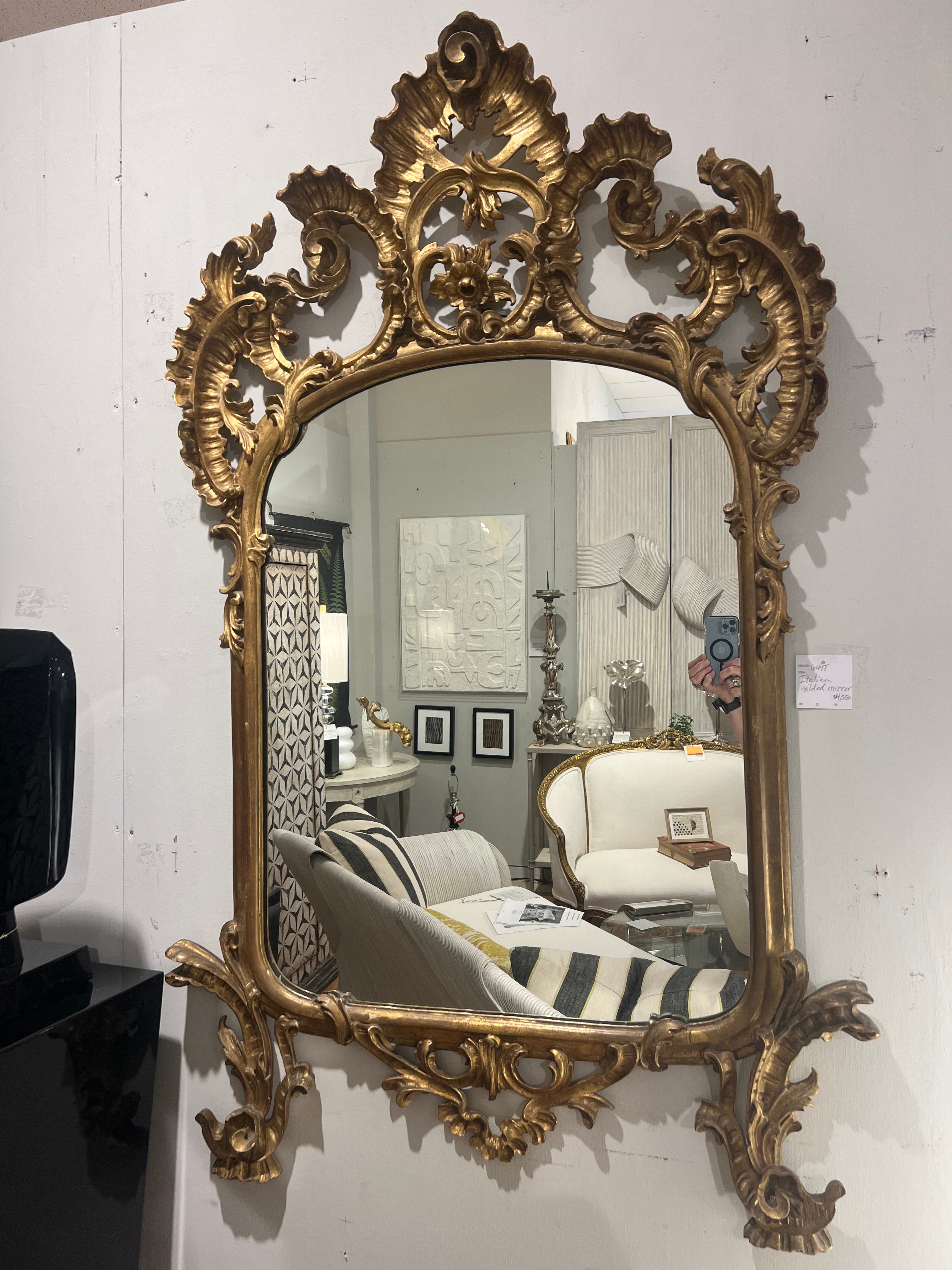 Italian gilt wood Belle Époque mirror. This richly hand carved mirror from the nineteenth century will be a striking accessory to any sophisticated room setting. It has minimal 