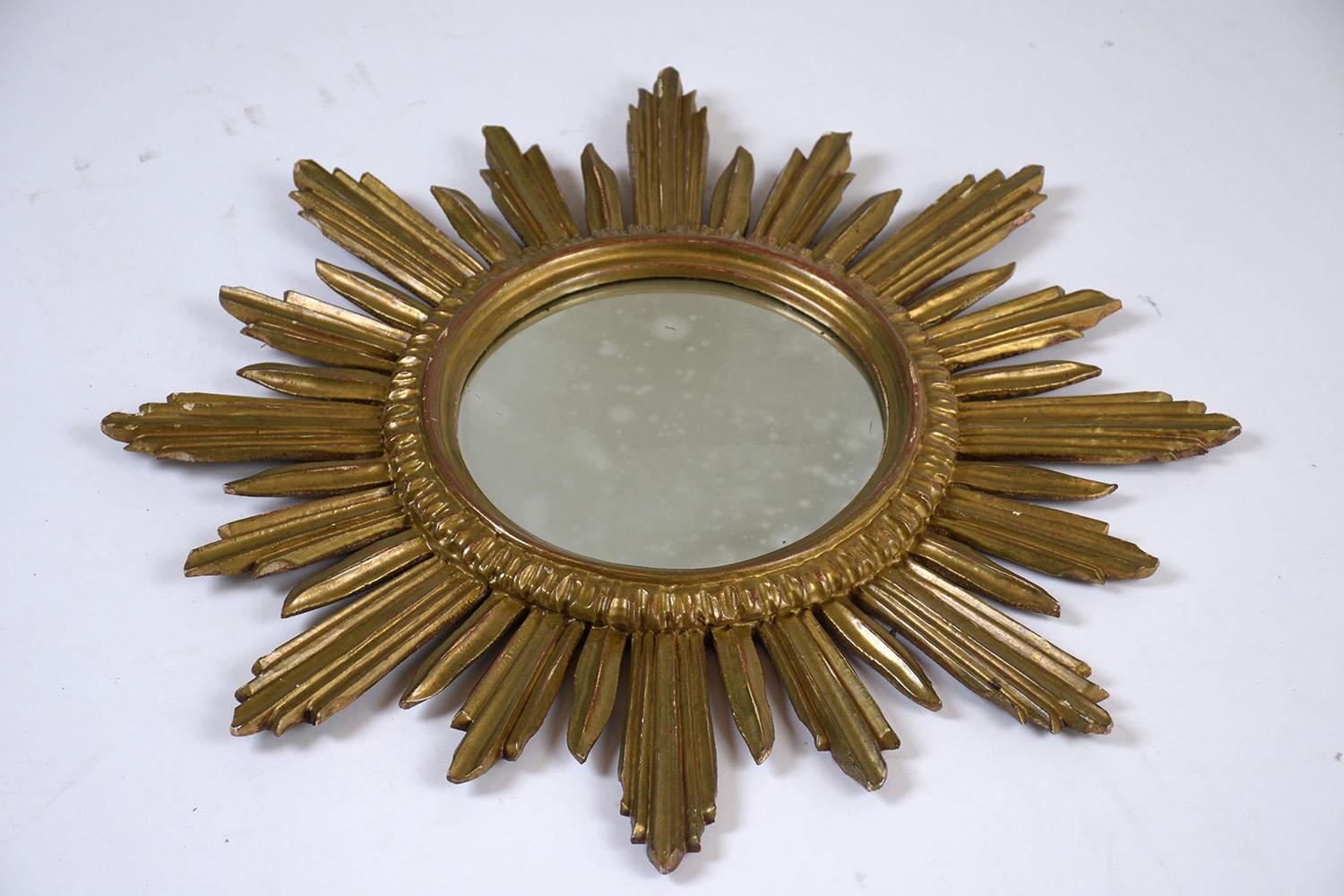 This lovely carved Italian convex sunburst mirror circa 1930s features a giltwood carved frame. The frame has rays encircling the mirror in varying lengths and shapes and original oxidized finish mirror This mirror is stunning and ready to be used