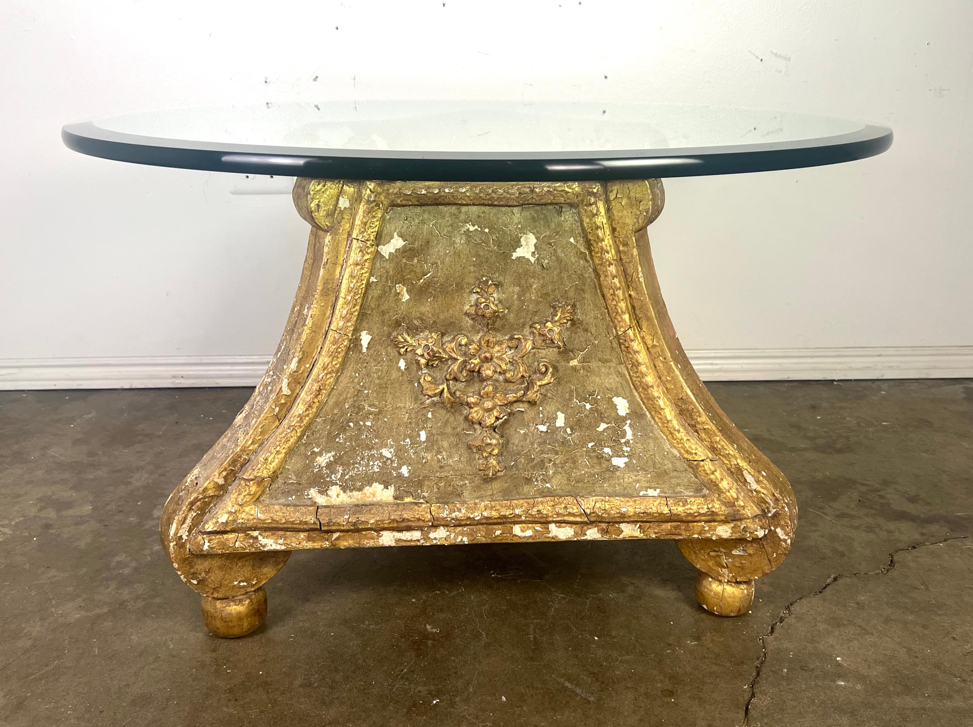 Dieser einzigartige Tisch hat ein eklektisches Design.  Die runde Glastischplatte mit abgeschrägter Kante bildet einen modernen Kontrast zum verschnörkelten Sockel.

Die Basis des Tisches besteht aus geschnitztem Holz und hat eine dreieckige Form