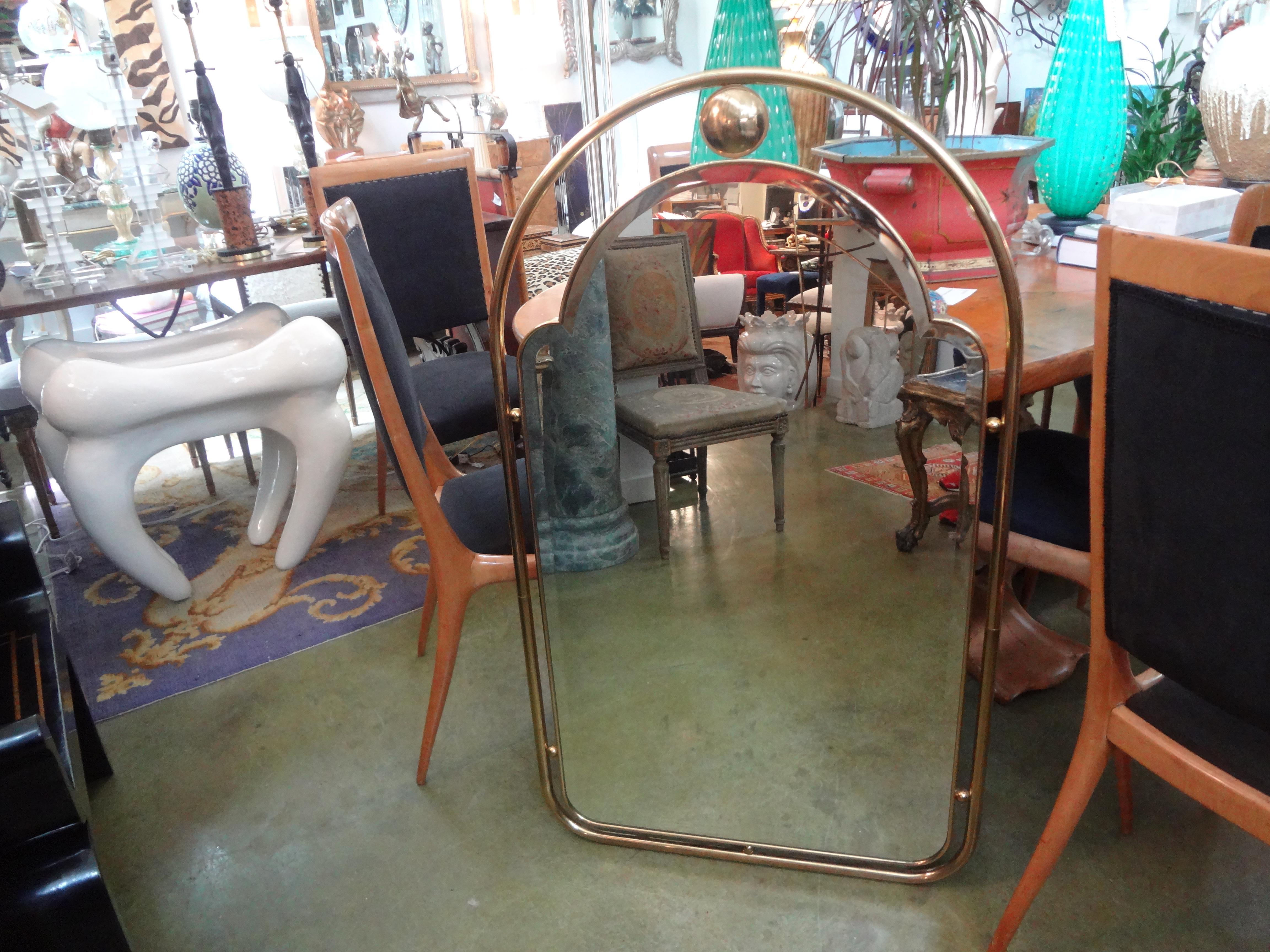 Stunning Italian Mid-Century Modern Gio Ponti style arched brass beveled brass mirror. This beautifully shaped well-made Italian mirror would look great over a console table, credenza, commode or chest.