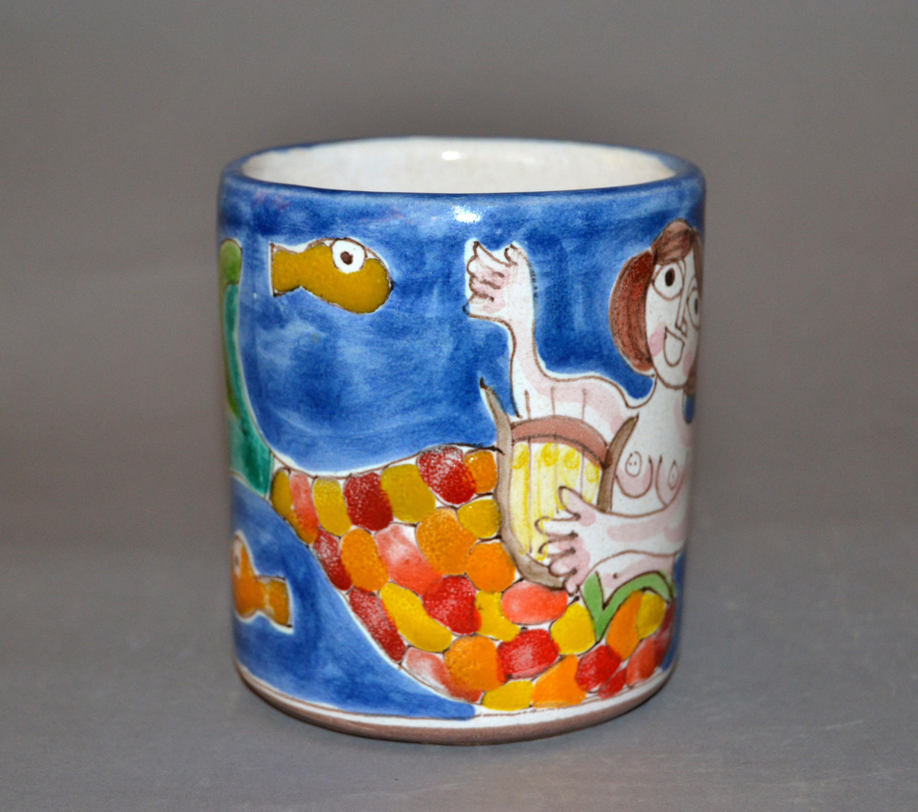 Original Italian Giovanni Desimone hand painted art pottery, decor mug or cup with a scene of a beautiful Mermaid playing the Harp surrounded by Fish.
The mug is glazed and very colorful.
DeSimone Mark and numbered on underside, 'Desimone, Italy