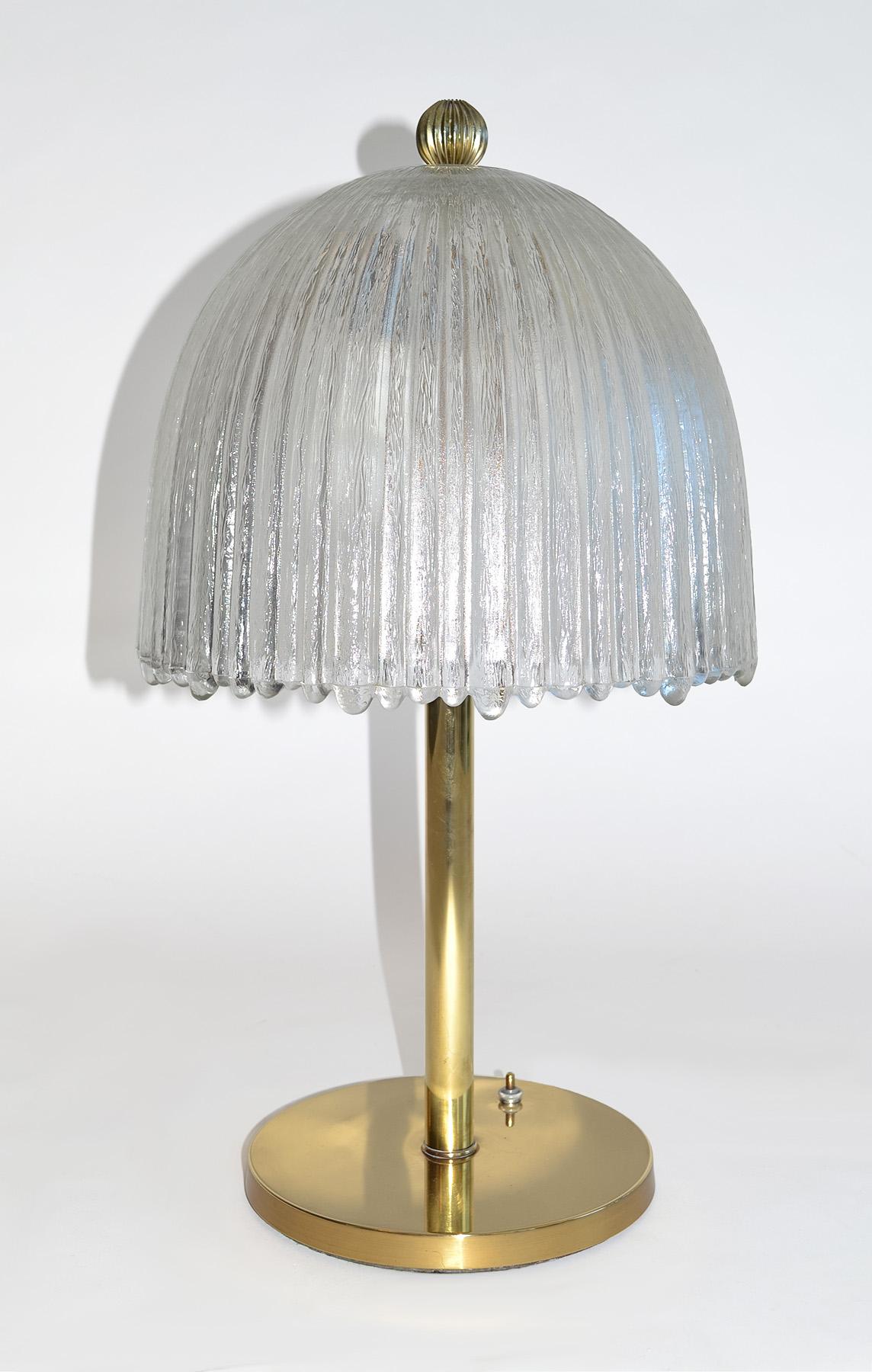 Italienische Tischlampe aus Glas und Messing Murano, 1960er Jahre
Tischleuchte aus Messing mit schweren, strukturierten, gerippten italienischen Glaskuppelschirmen, gekrönt von einem Messingknauf. Nach dem Vorbild von Venini. Steckdose mit zwei