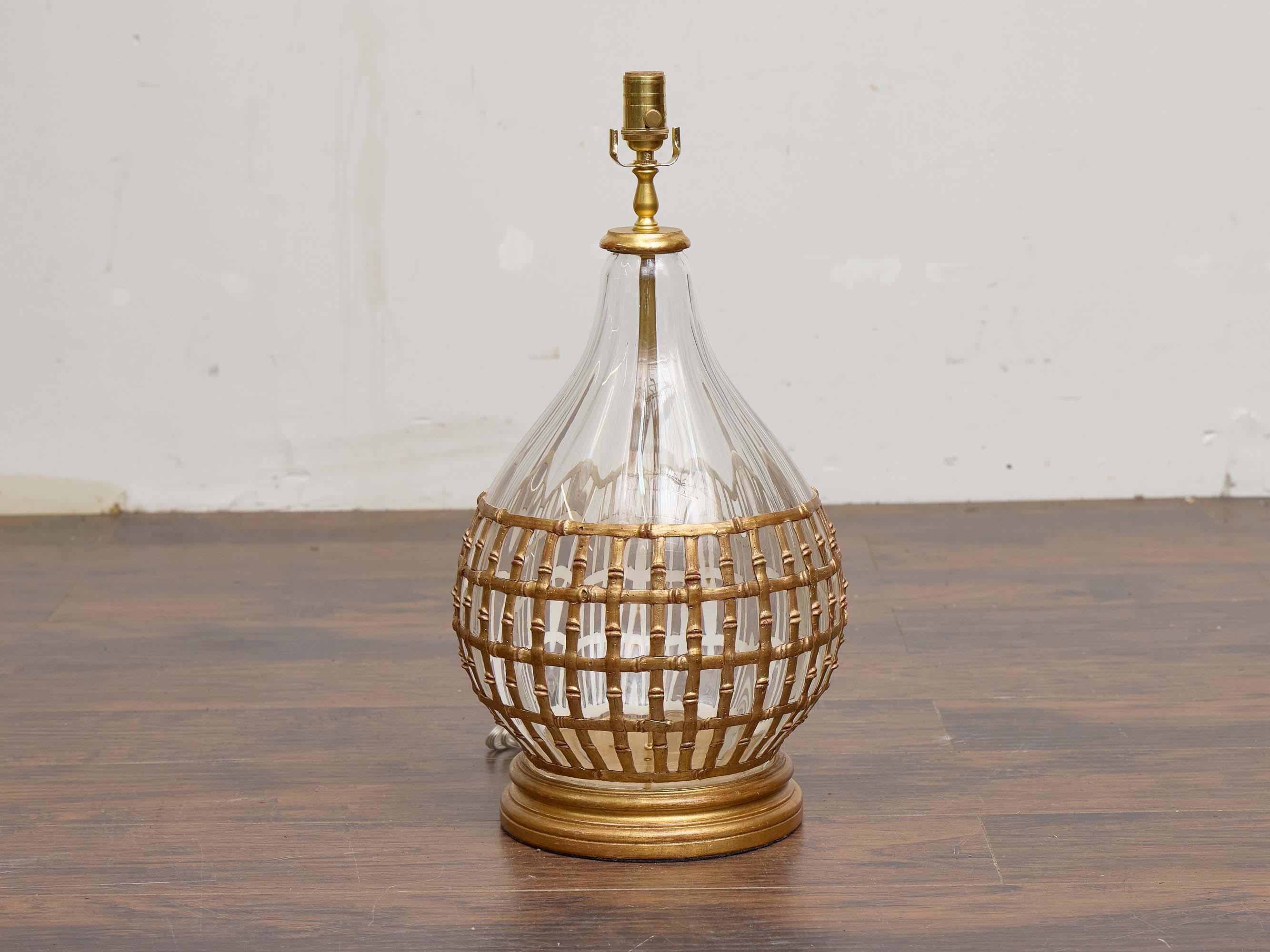 Questa lampada da tavolo italiana del 1950 circa combina l'artigianato tradizionale con una raffinata sensibilità da metà secolo. Il corpo in vetro trasparente a forma di goccia è racchiuso in un reticolo di bambù delicatamente intrecciato a mano,