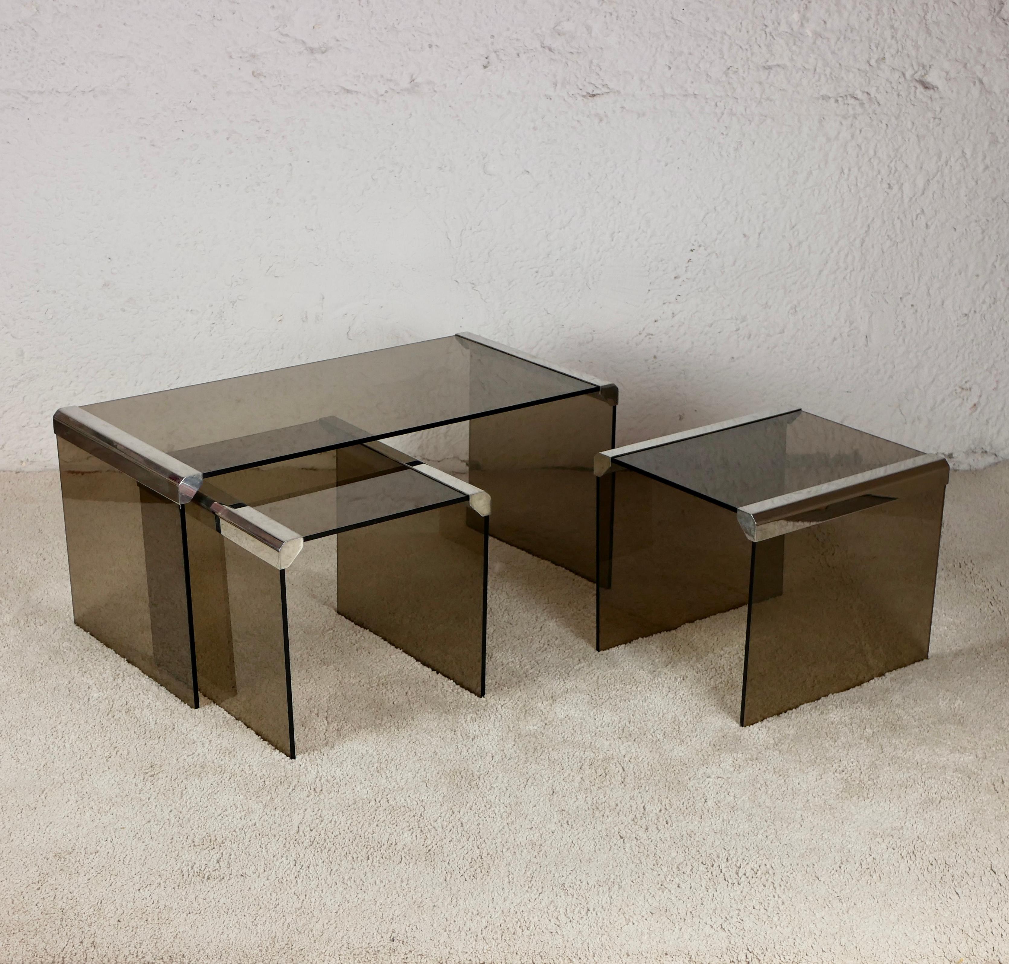 Gorgeous nesting tables designed in the 1970s by Pierangelo Gallotti for Gallotti & Radice, made in smoked glass and metal.
Very elegant and rare in this shape.
One small impact (see photos) on the side of one of the small table.
We also have one