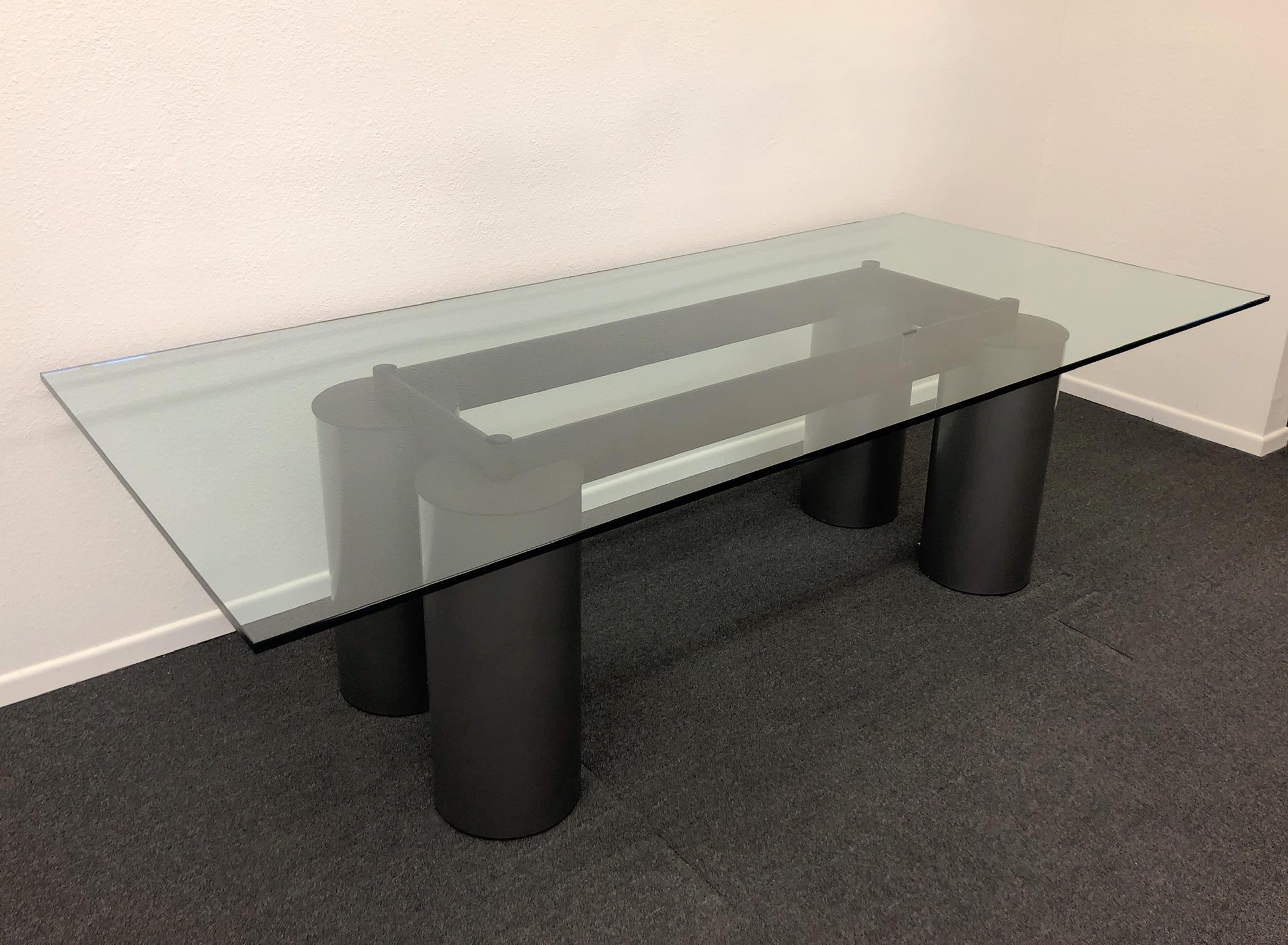 Italian Postmodern Memphis dining table designed by David Law, Lella & Massimo Vignelli for Acerbis International in the 1980s. The table is constructed of powder coated steel and glass. The cylinder legs are metallic gray powder coated steel. The