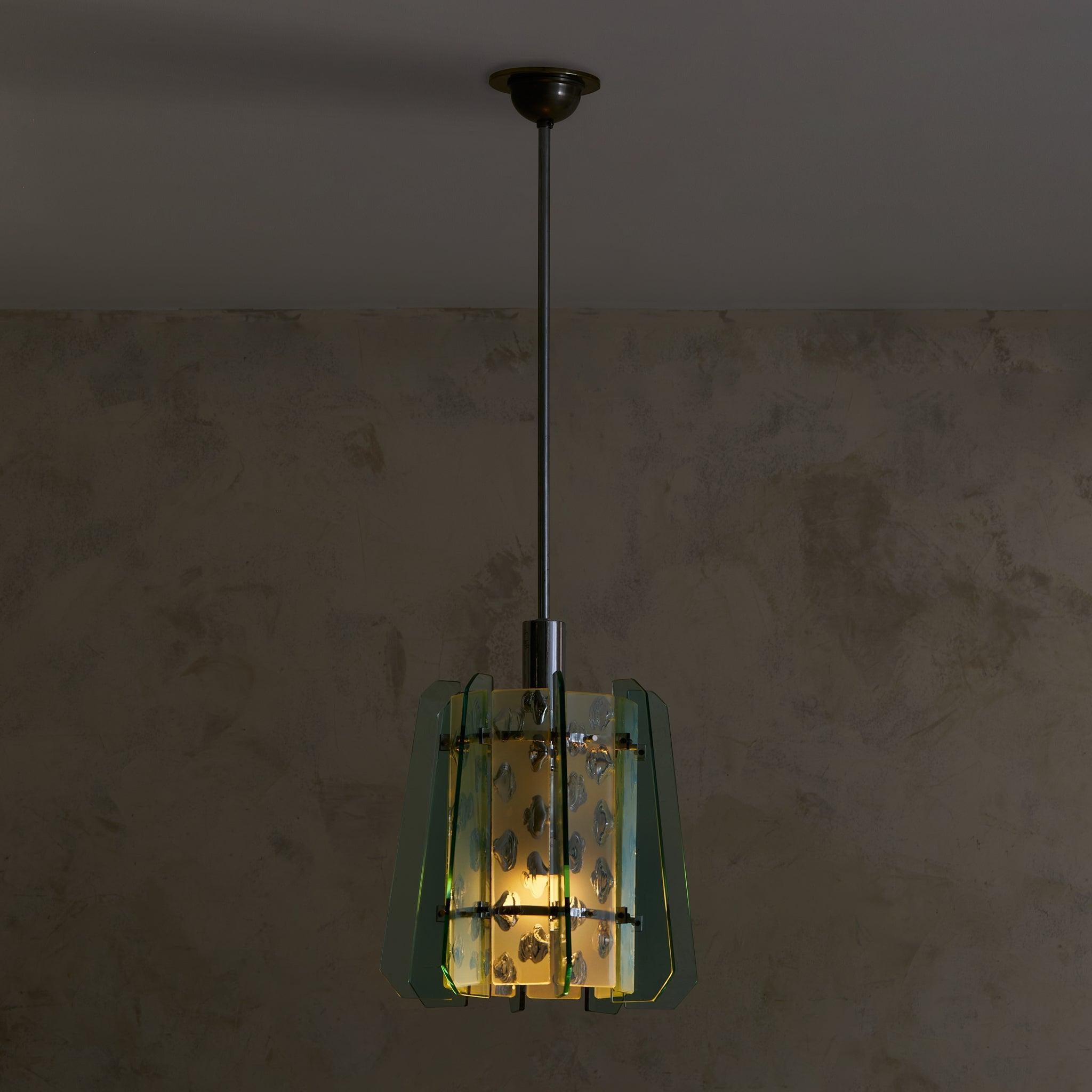 A 1950s Italian pendant light that evokes the refined aesthetic of Fontana Arte. Angular aquamarine glass panels frame a textured central diffuser, playing with transparency and light to cast a soft, ambient glow. Polished nickel hardware