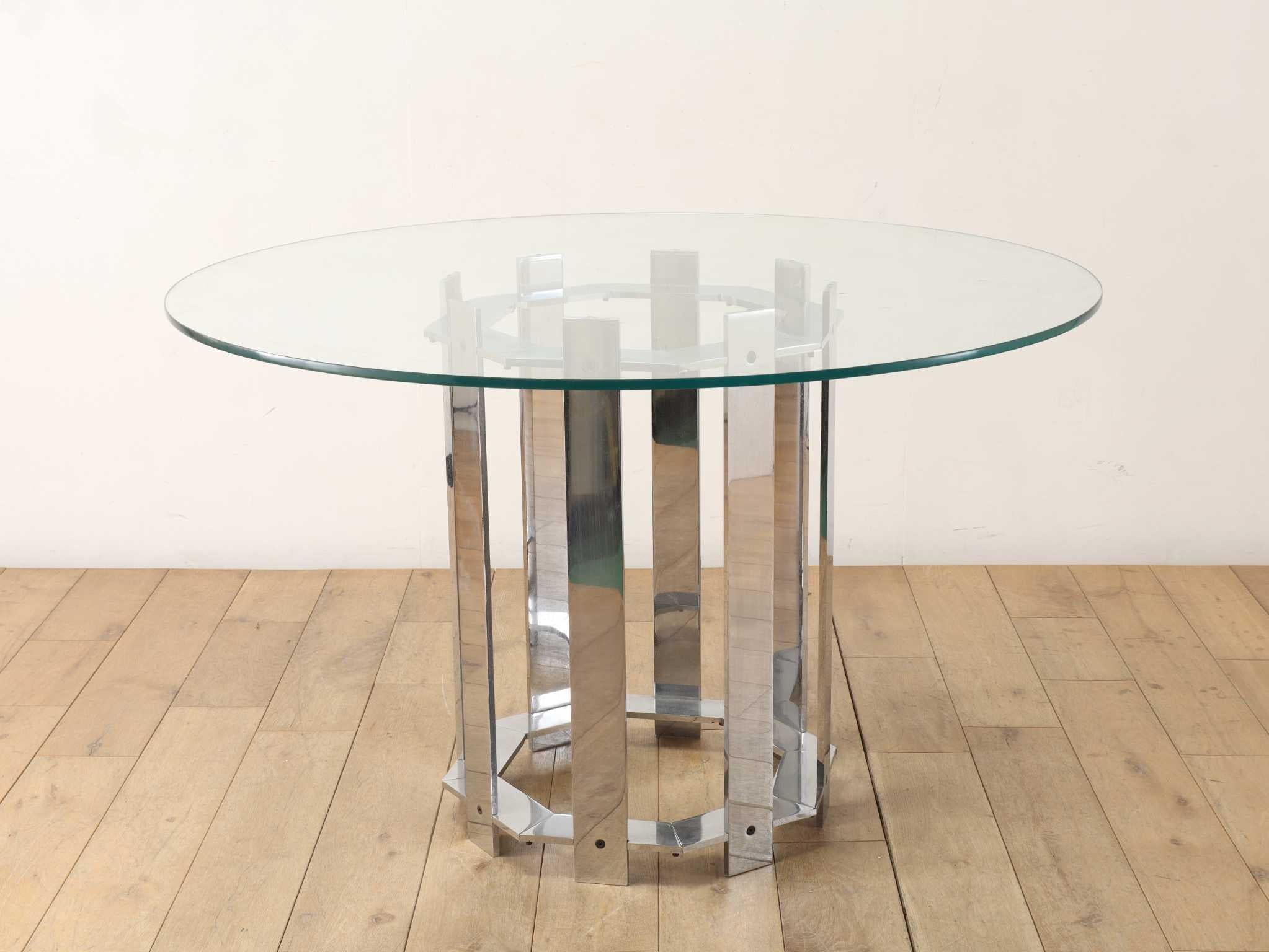 This round table presents a striking combination of clear glass and polished chrome, creating a cool and sophisticated impression. The contrast between the transparency of the glass and the metallic luster of the base results in a modern aesthetic