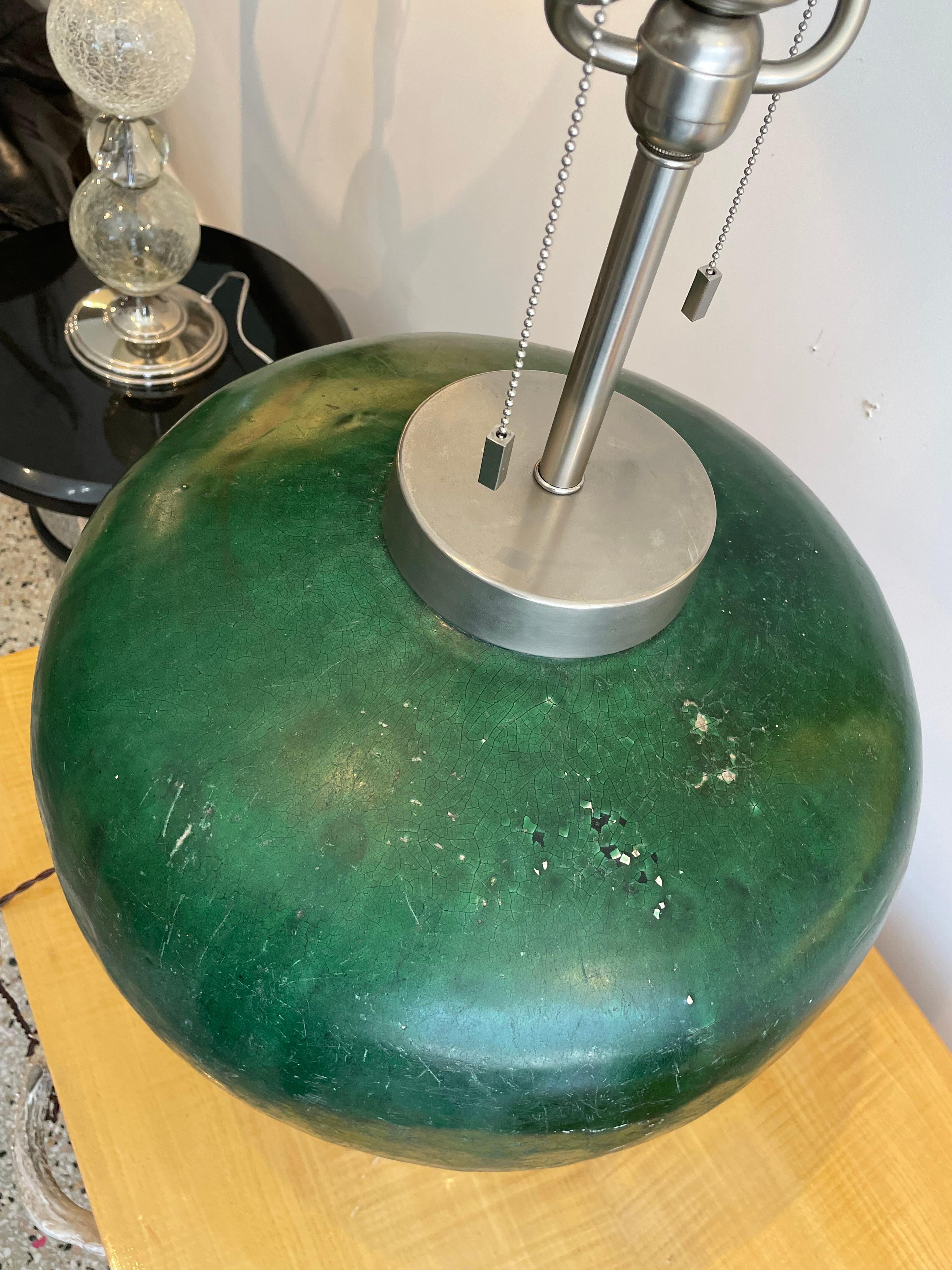 This large scale, chic and dramatic table lamp dates to the 1980s, and the piece is fabricated with antique glazed amphora, in a deep emerald green glaze. 

Note: See images which show wear spots to the glaze.

Note: Dimensions of the lamp not