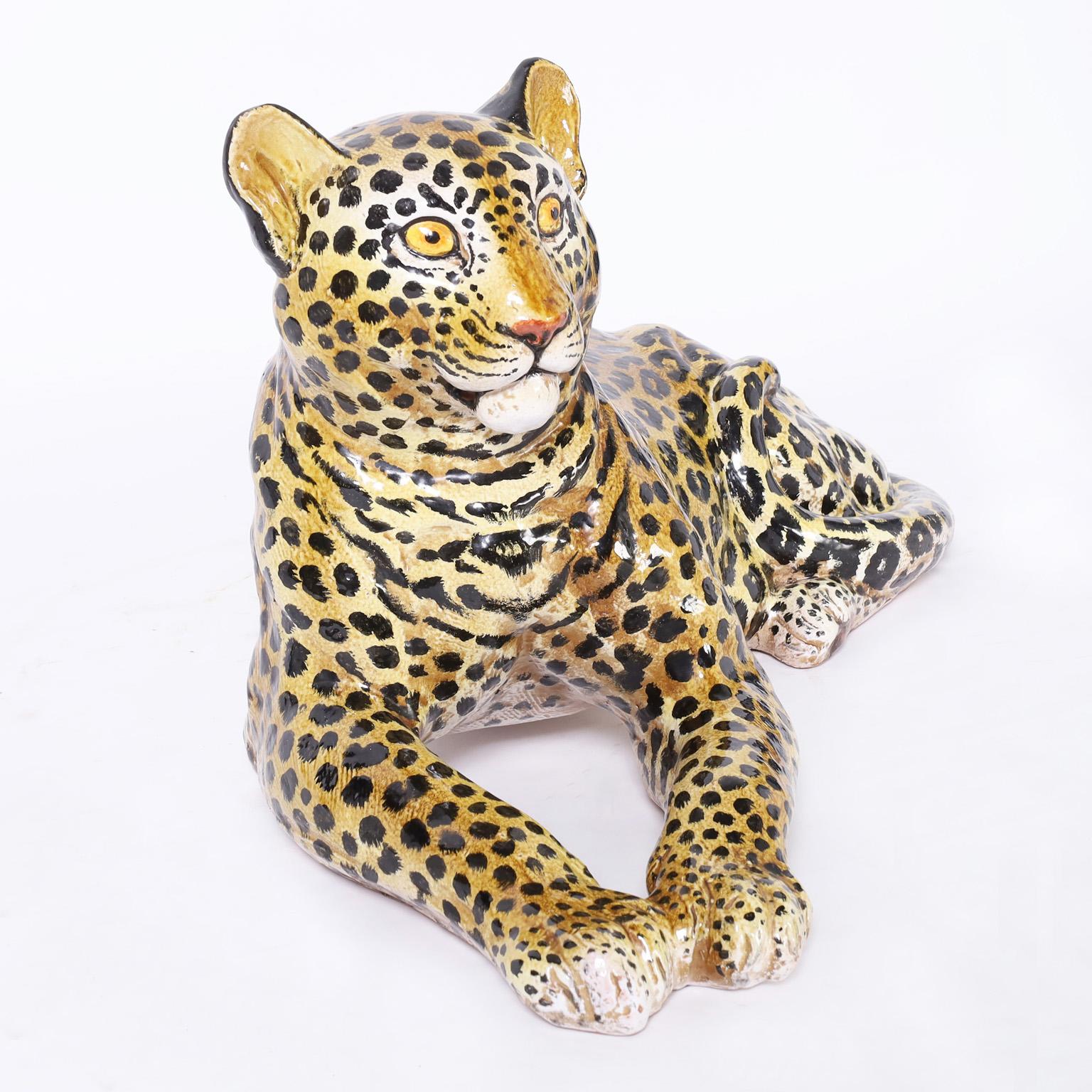 Mid century life size leopard in repose with its iconic spotted coat, crafted in terra cotta, decorated and glazed.