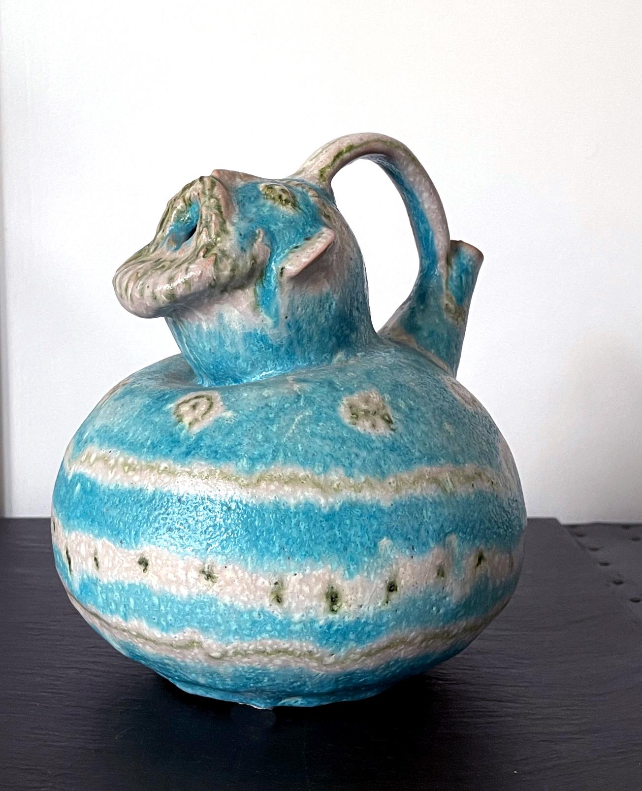 A stoneware pitcher with stirrup handle by Guido Gambon, Italy, circa 1950-60s. Beautifully glazed in blue and white color and lava-like texture and highlighted with signature green geometric lines and circles and dots. What's unusual of this pot is