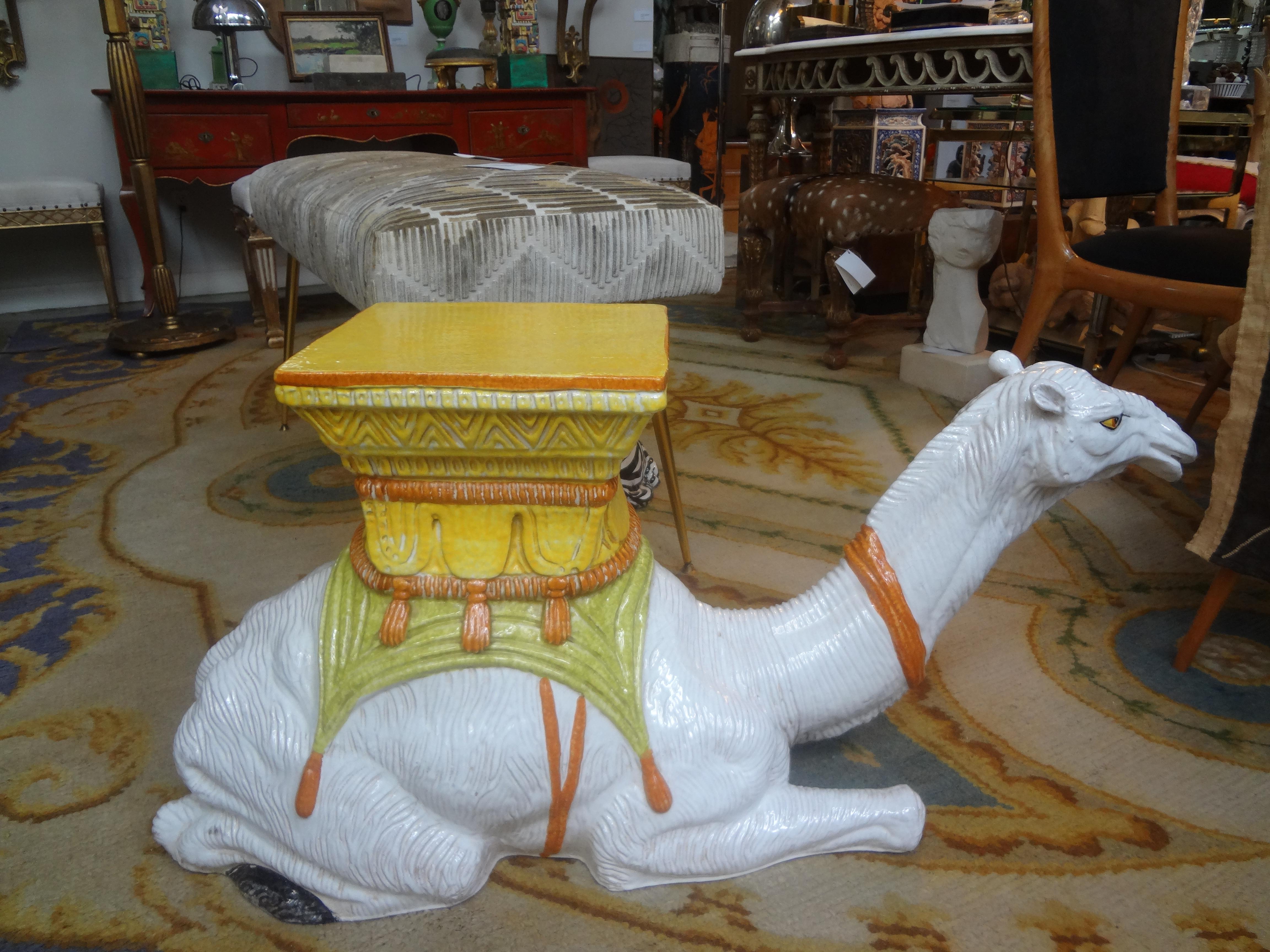 Italian glazed terra cotta camel garden seat or table. This handsome Hollywood Regency glazed terracotta camel table is executed in great yellow, orange and soft green. A versatile piece that could be used indoor or out.