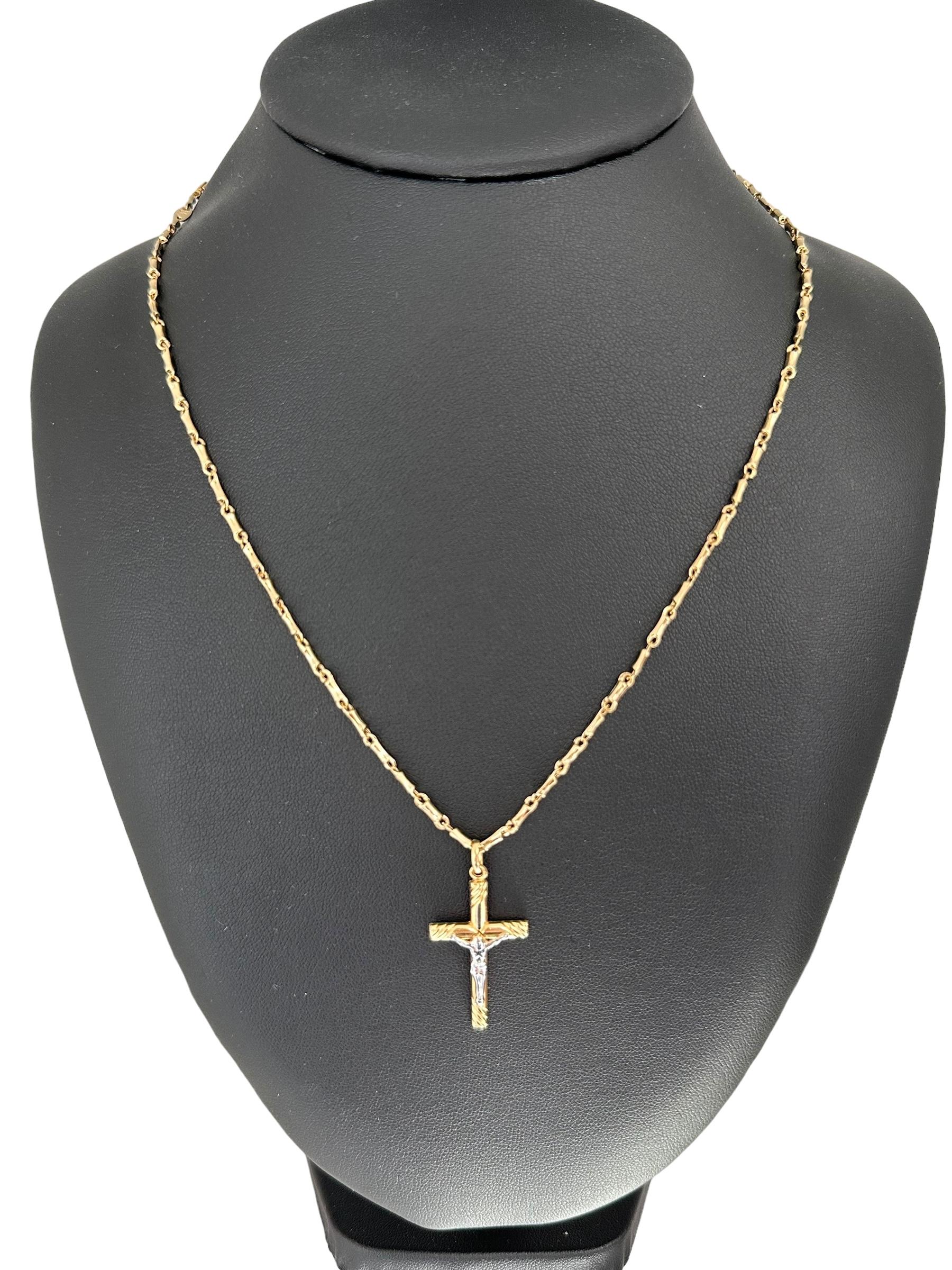 This Italian Gold Crucifix with Bamboo Links Chain is a beautiful and meaningful piece of religious jewelry. Crafted from high-quality 18kt yellow gold, the crucifix features intricate detailing and a polished finish, highlighting its exquisite