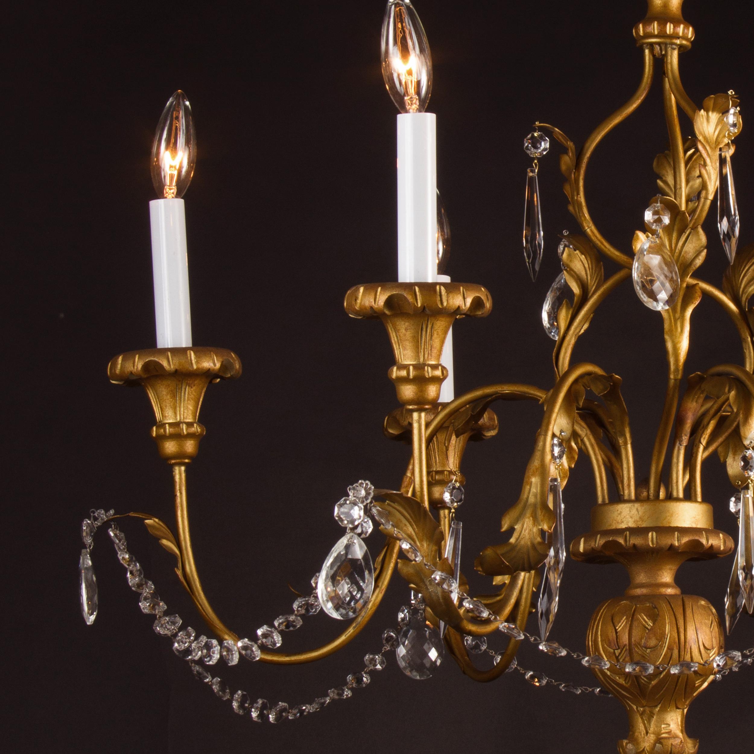 This beautiful Italian chandelier is made of gilded (gold leaf covered) Iron, hand painted wood, crytsal and tole. The piece dates back to the mid-20th century and features a lovely spiral aesthetic along its center stem. Decorative furling leaves