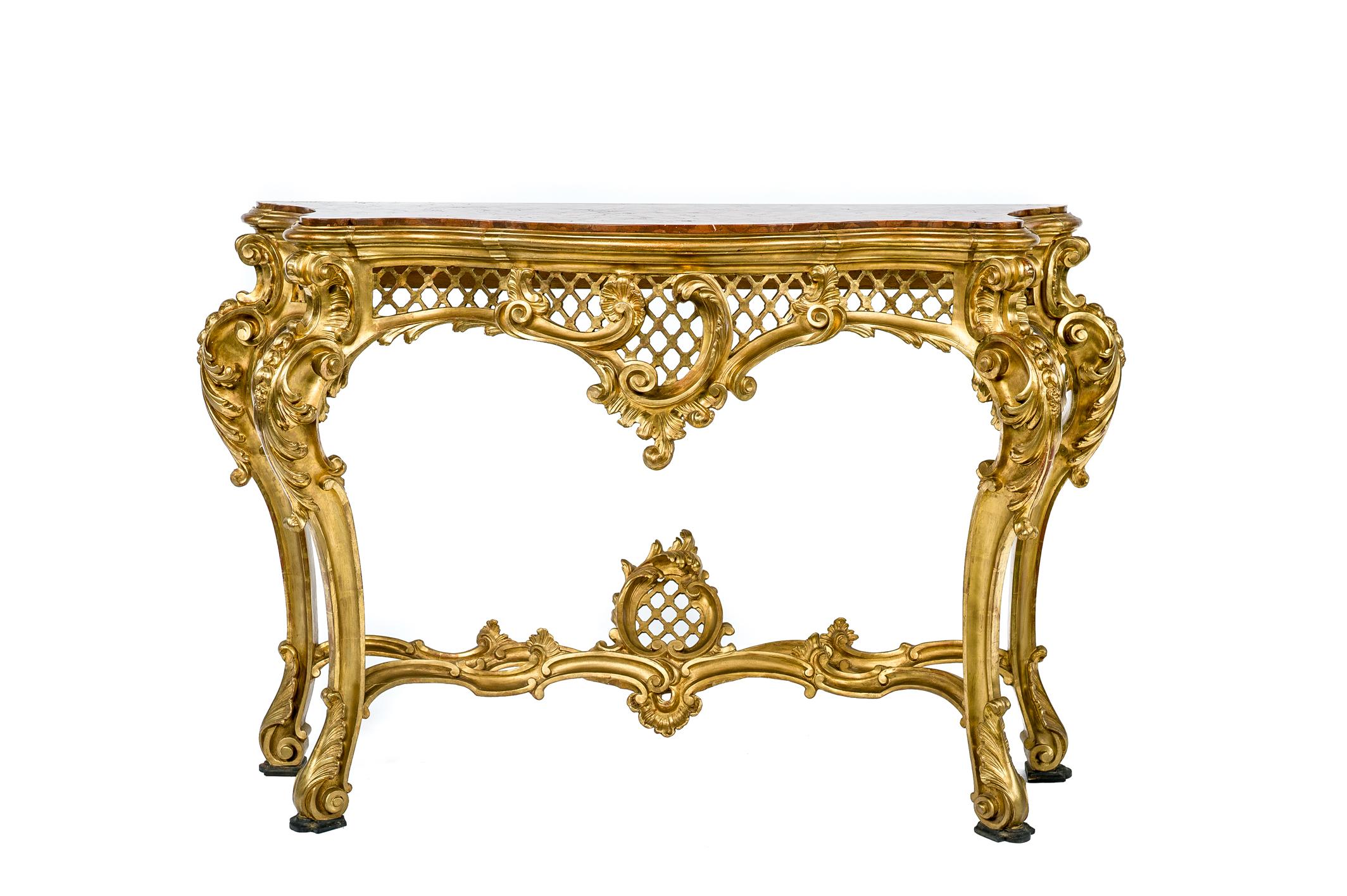 Beautiful Italian Rococo console table with inserted top of rosso verona marble. 
This console table has a pierced skirt centered by a rococo foliate ornament with complex volute floral and foliate carved cabriole legs. The legs are jointed by