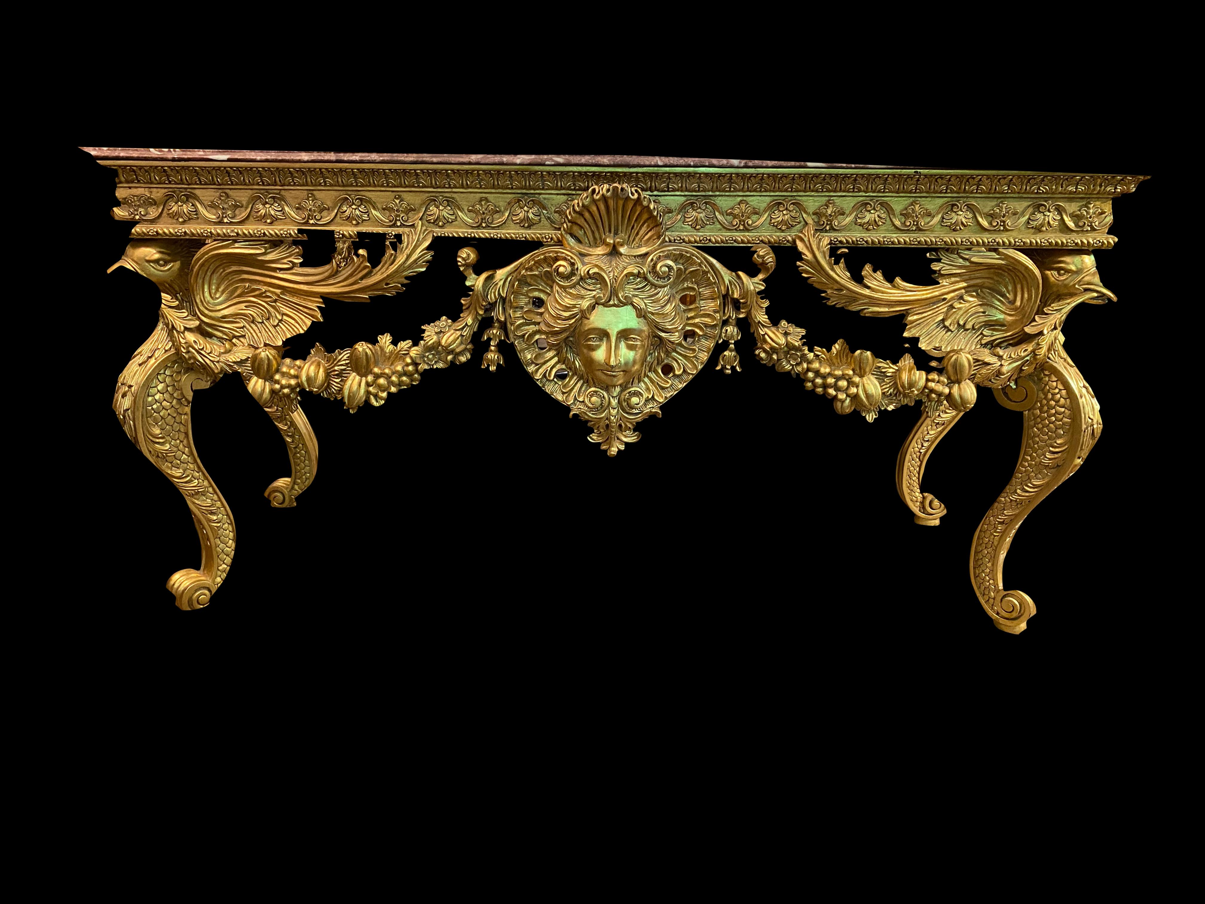 A beautiful large Italian gold gilded Rococo console table with Rosso Verona marble top and griffin legs.
This console table has a pierced skirt centered by a rococo foliate ornament with complex volute floral and foliate carved cabriole and
