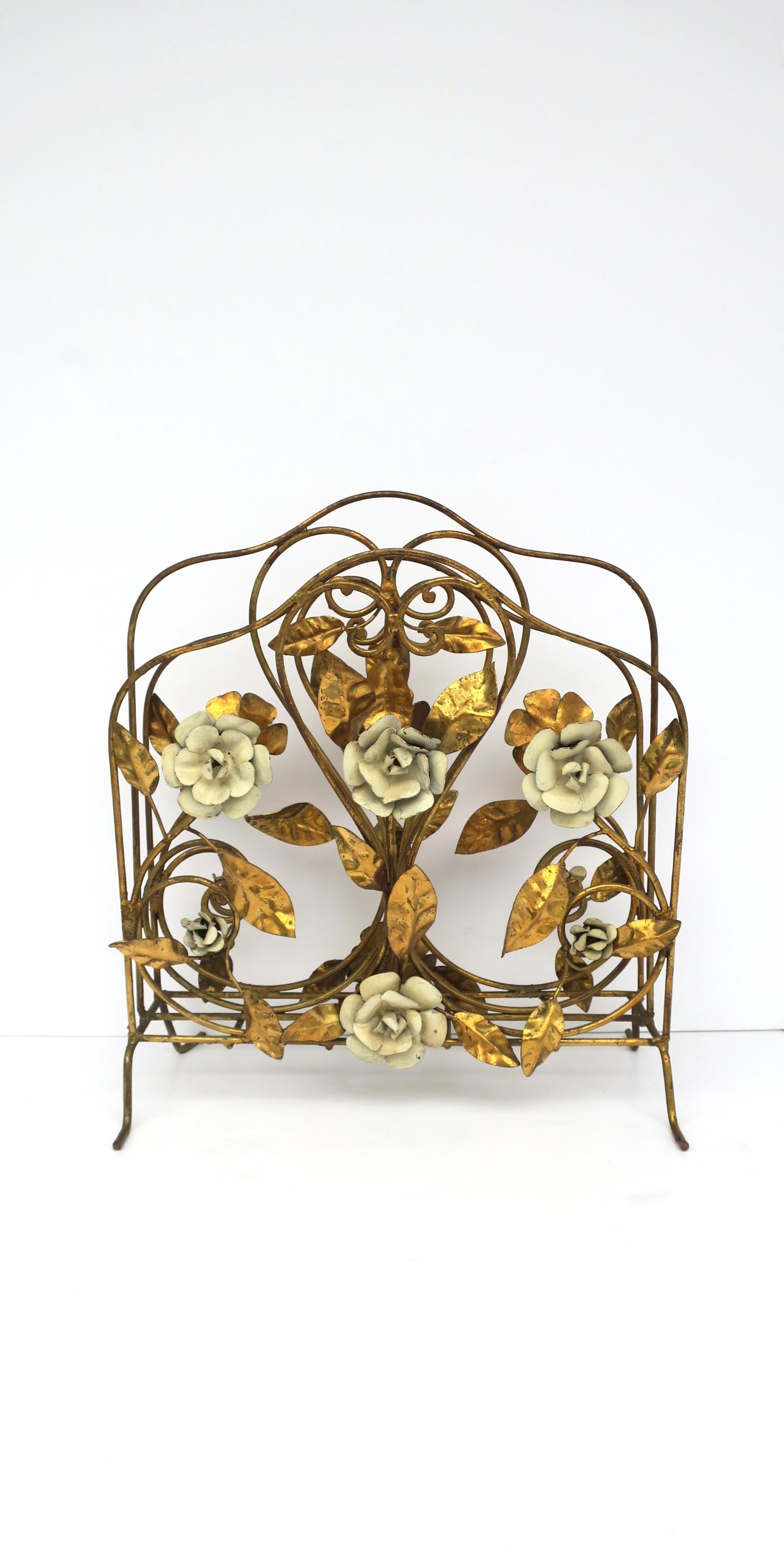 A beautiful Italian gold gilt and enamel magazine holder rack with flowers and leaves, circa mid-20th century, 1950s, Italy. Holder has beautiful enamel flowers and gold gilt leaves on front and back. Piece has two storage compartment areas to hold