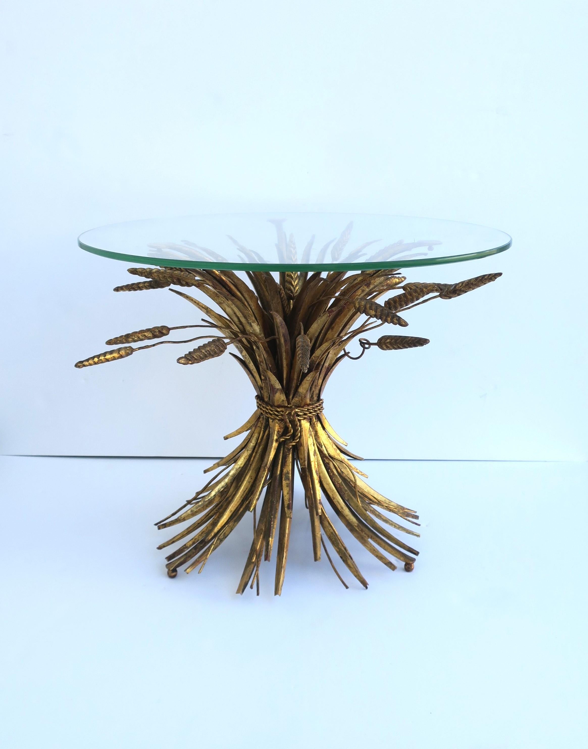 A beautiful Italian gold gilt metal Sheaf of Wheat end, side or drinks table, Hollywood Regency style, circa mid-20th century or earlier, Italy. Piece has gold gilt metal 'Sheaf-of-Wheat' base, finished with a round glass top. Table is aka the 'Coco