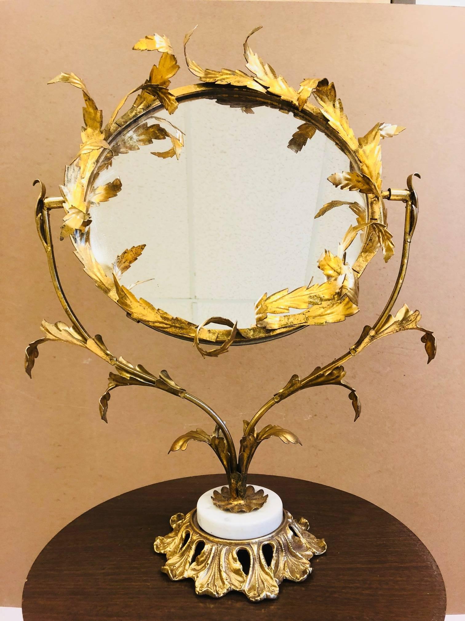 Gold gilt table or vanity mirror. Frame gold gilt metal with a floral pattern. Base is marble.
Measures: 24.5
