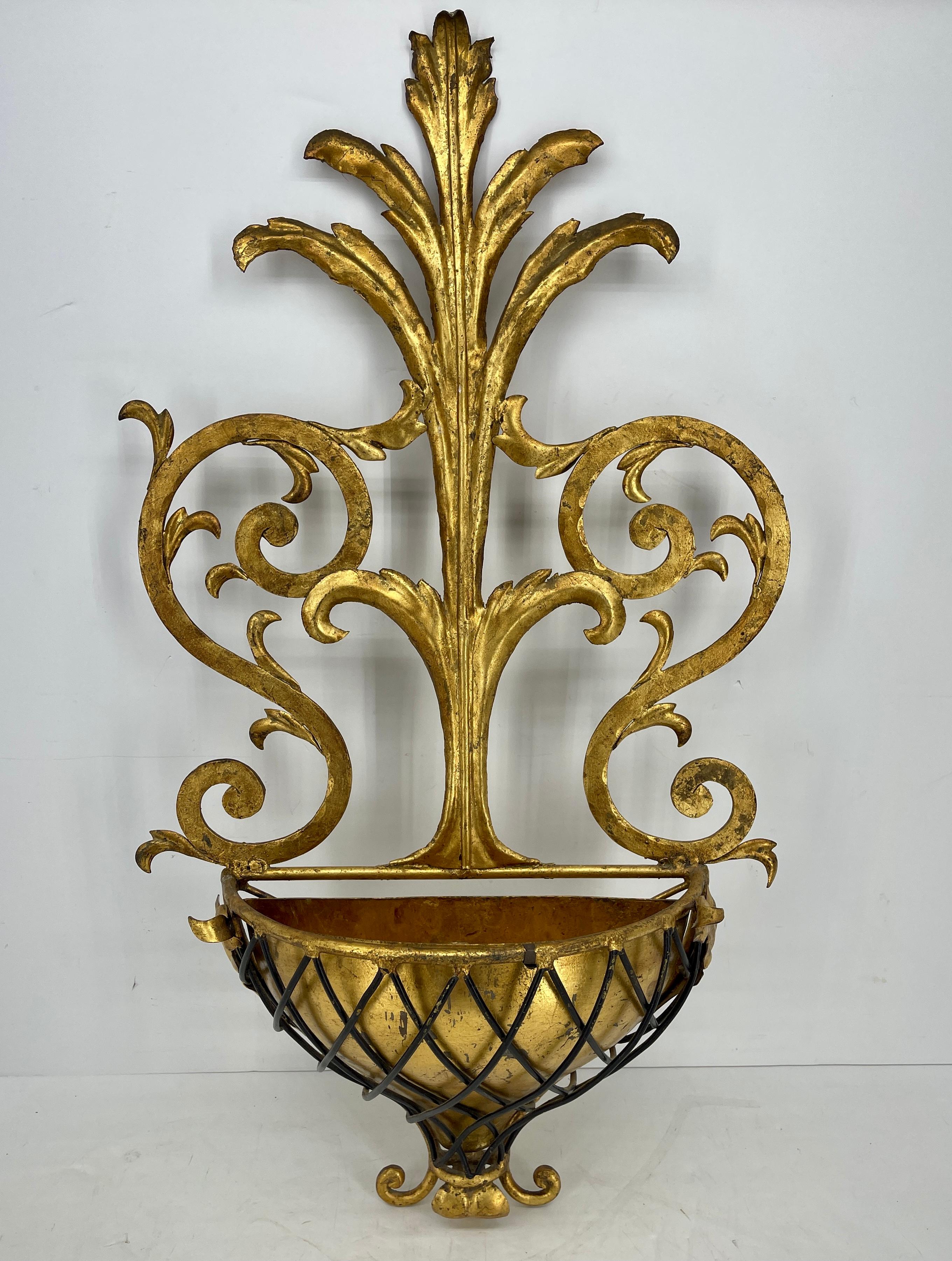 Mid-Century Modern gold gilt wall planter, Italy circa 1950's.
This beautiful wall planter cachepot is ornately scrolled with decorative black iron enhancing the demi-lune shaped plant holder in the center. The piece has an insert pot/basket to