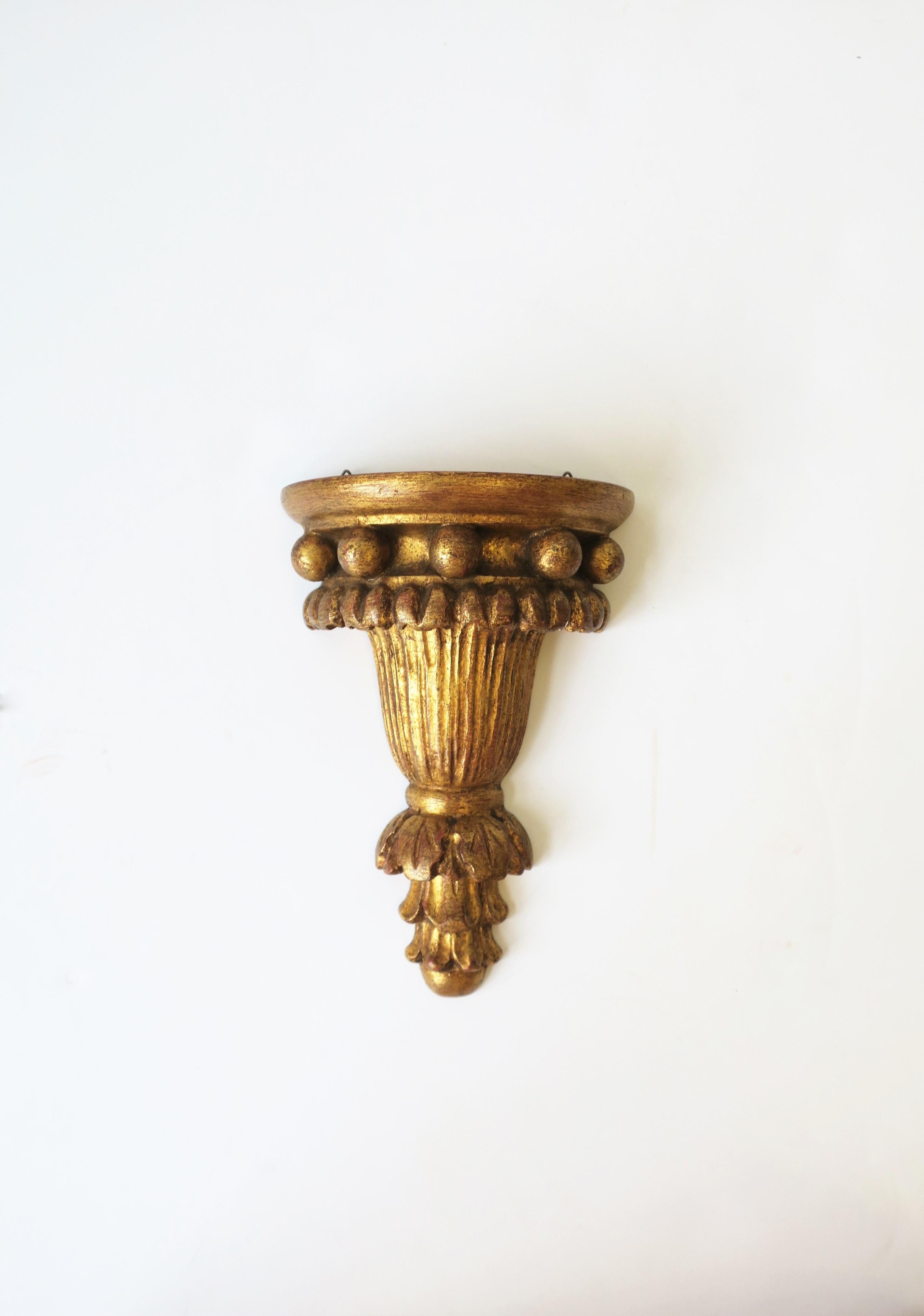 A beautiful, small, Italian gold gilt wall shelf bracket with ball motif and acanthus leaf design, circa mid-20th century, Italy. Piece is hand carved and finished with gold gilt over plaster and wood. Marked '