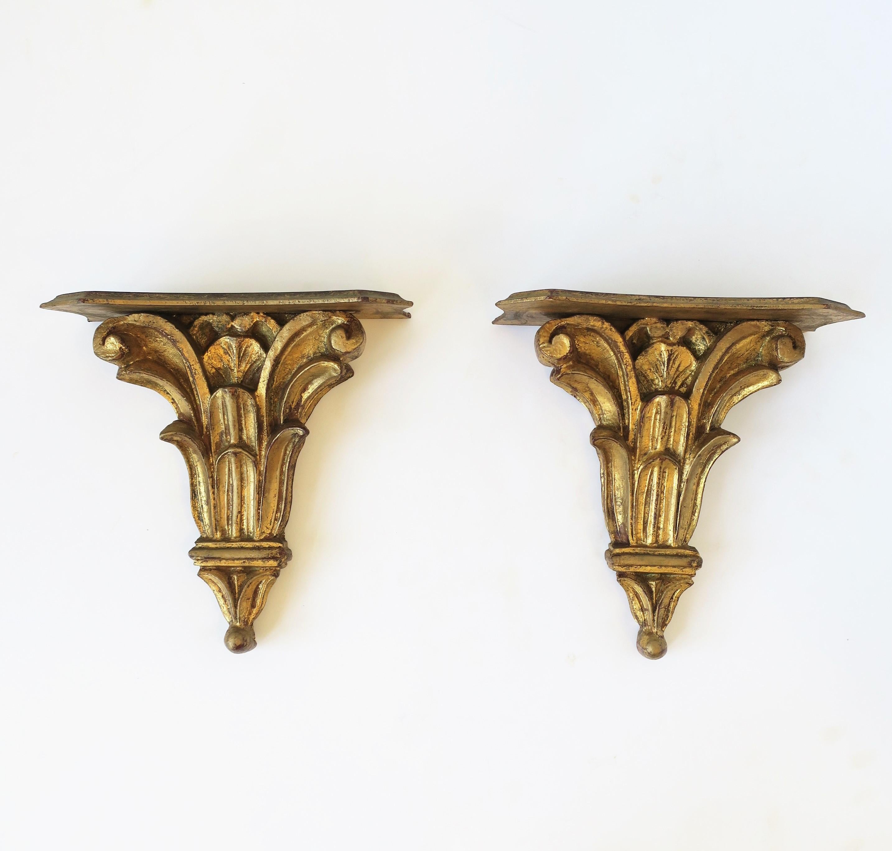 A beautiful pair of Italian gold giltwood gold-leaf wall shelves with acanthus leaf design in the neoclassical style, circa early 20th century, Italy. Each are marked on back 