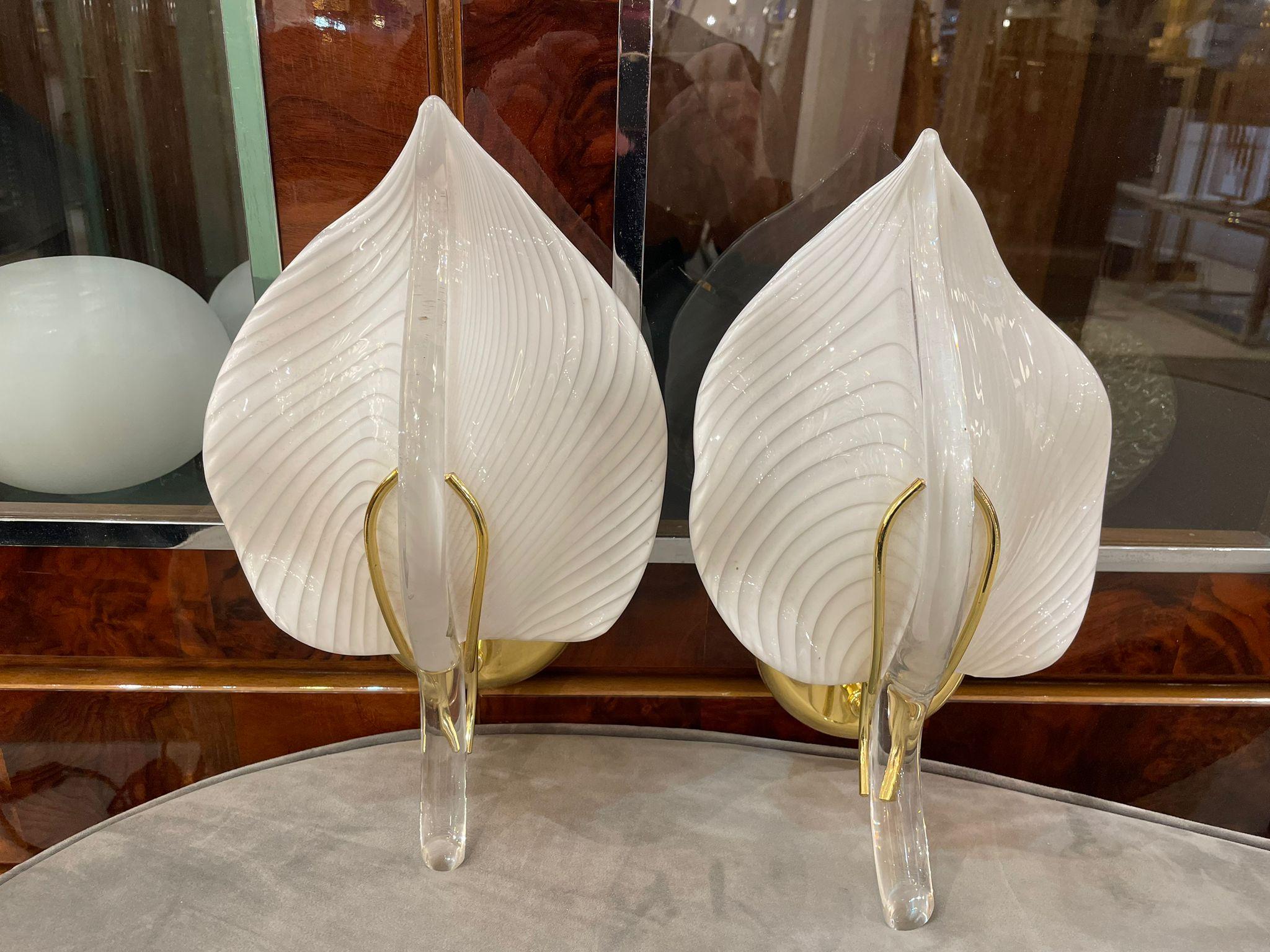 Elegant Wall Lights in gold plate adorned with three white leaves in Murano glass. Italy 1960s.
