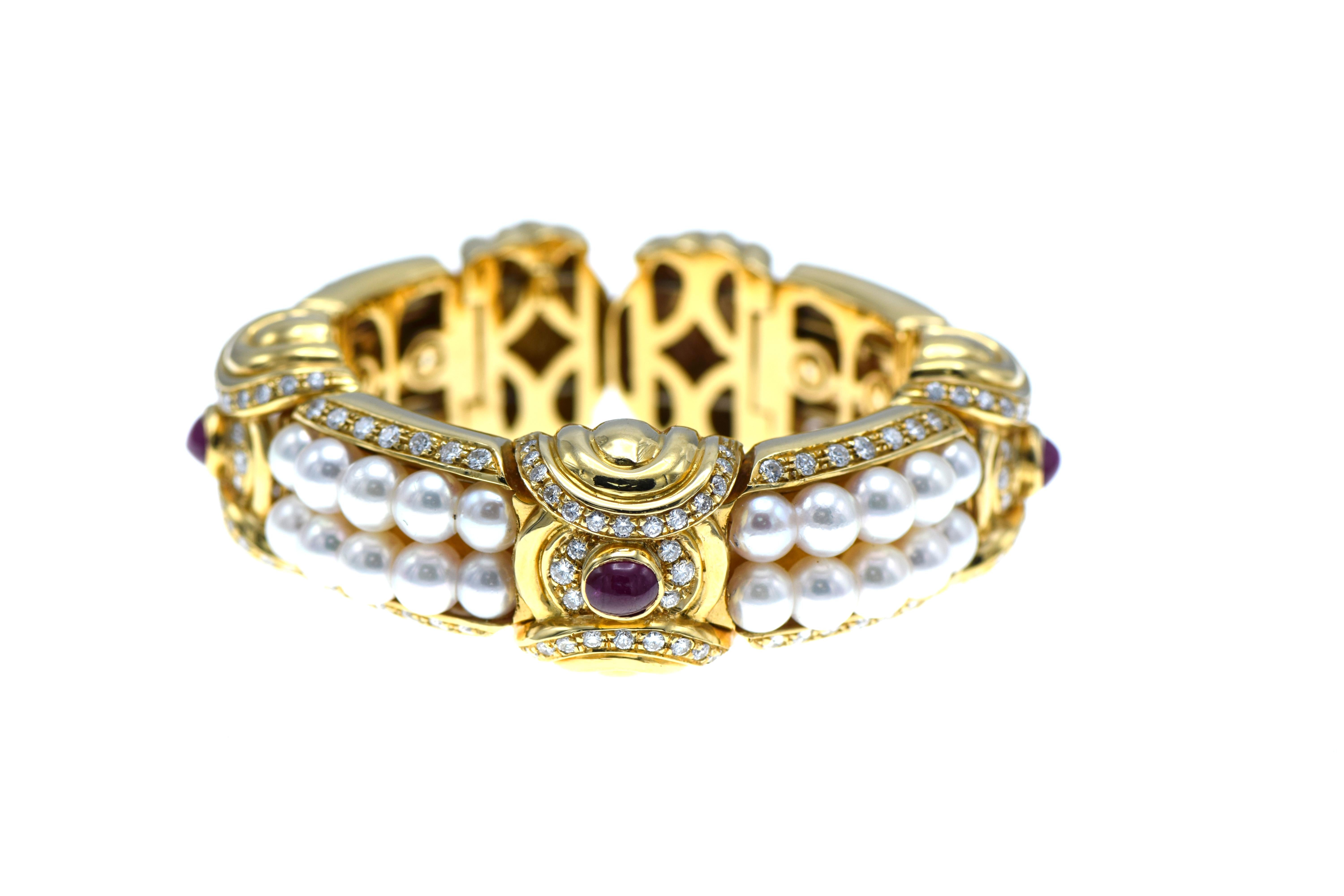 Crafted in 18 karat yellow gold, expandable cuff bracelet in the style of Bulgari.  Featuring 3 oval cabochon cut rubies 152 round brilliant cut diamonds and 40 cultured pearls, 6-6.50mm of fine quality, very slightly blemished, very high luster and