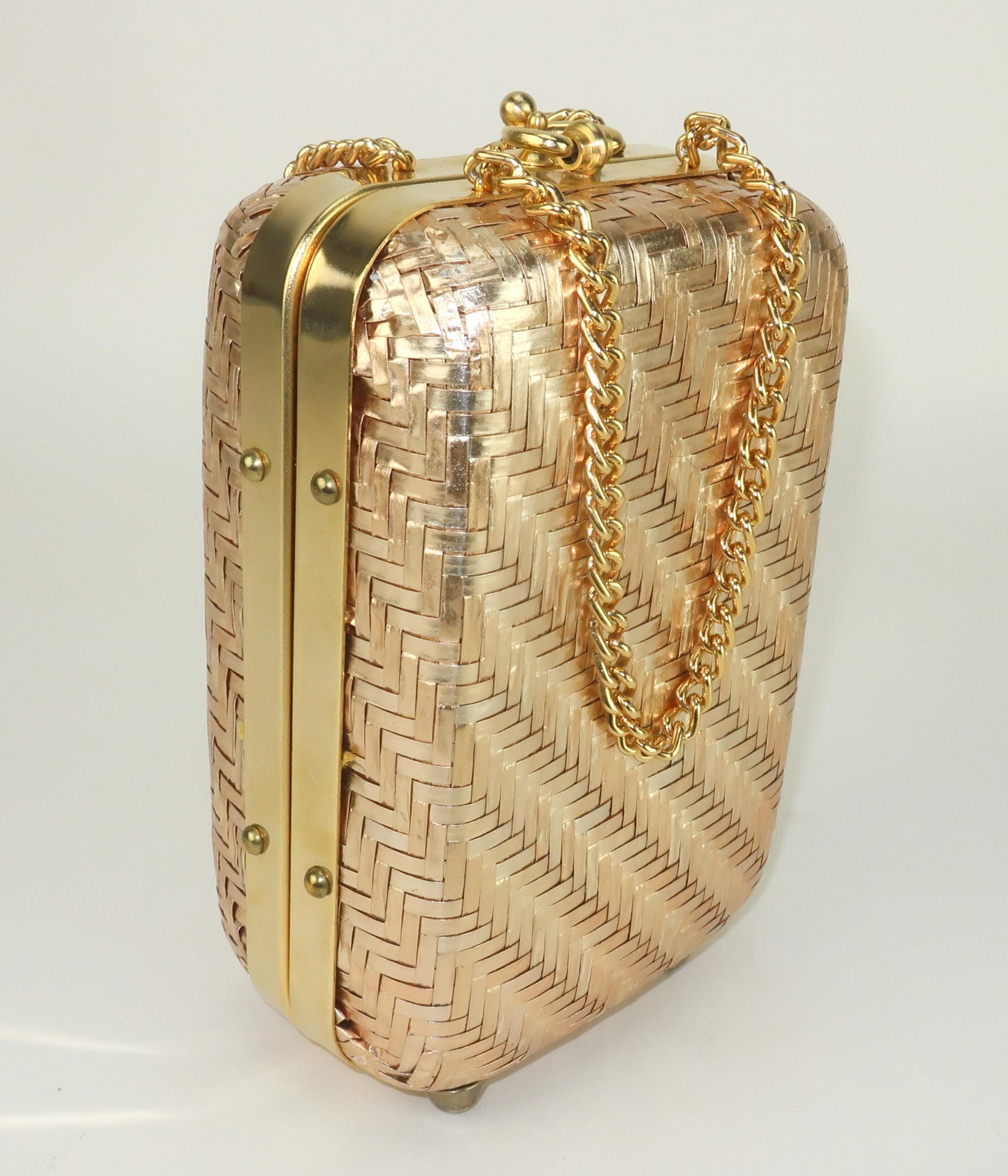 1960’s Italian gold straw casket shaped handbag with double chain handles.  The gold is a matte hue with a hint of champagne to the finish.  The gold tone metal frame is accented with studs and the handbag sits upright with cone shaped feet.  The