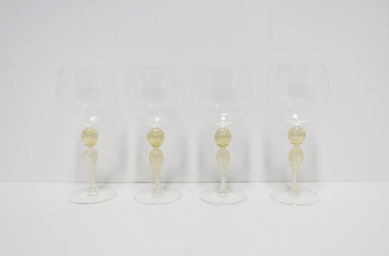 A beautiful set of four (4) Italian Venetian Murano gold and transparent art glass wine goblet glasses, circa early 21st-century, Italy. Enjoy white or red wines with these beautiful glasses. Great for any bar, bar cart, entertaining area, yacht,