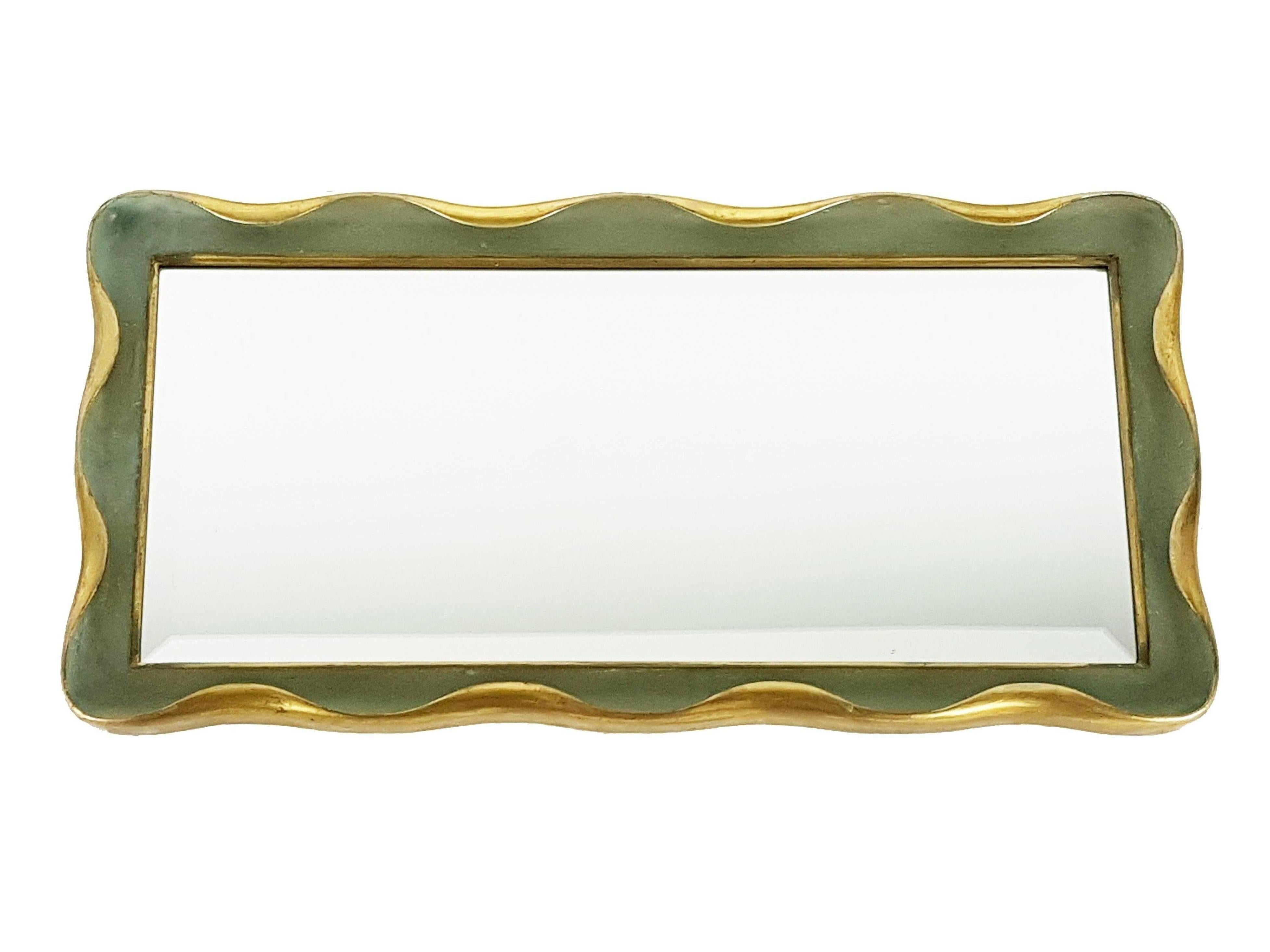 This wall mirror is made from a laquered and golden wood frame with a faceted mirrored glass. It can be used both horizontal and vertical orientation. Its design and its fine quality resembles similar works of Giovanni Gariboldi from the 1940s. Very