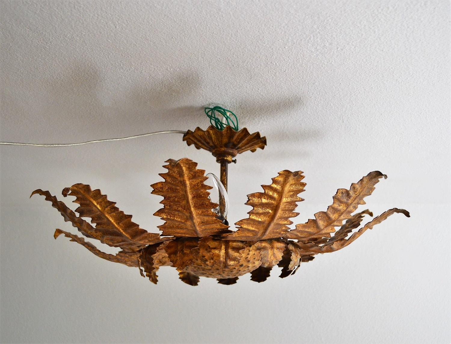 Exceptional beautiful and rare pendant lamp in the form of a thistle made of strong gilt metal leafs.
Made in Italy, circa 1960s.
Hollywood Regency style.

This big flower lamp is a handmade artist work of cut rough iron leafs, rivet together to