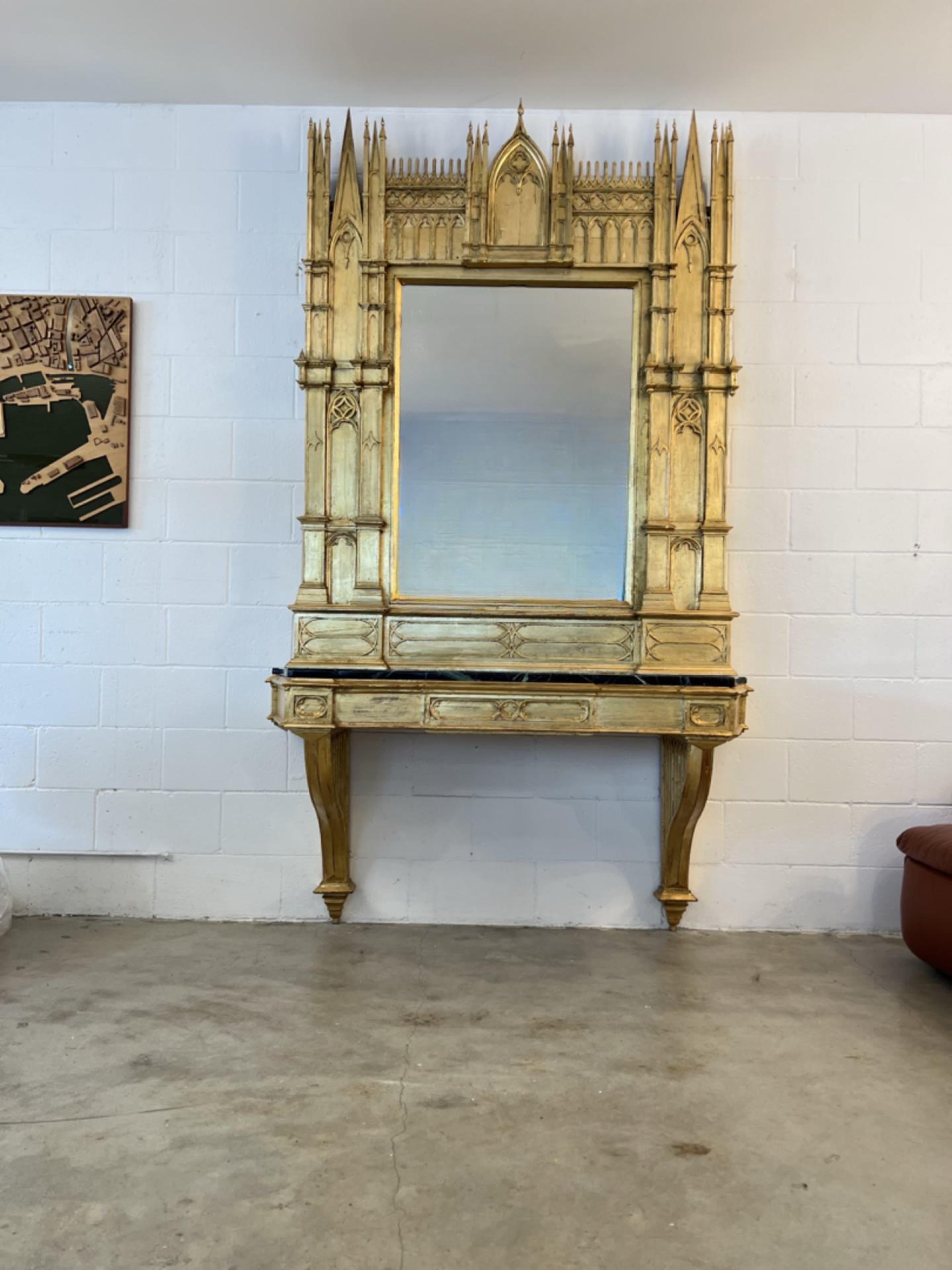 Italian Gothic gold leaf mirror console with black marble top 1920s.
Statement piece completely cover in gold leaf by Paolo Lumini, he restored the all piece giving a a completely fresh look and a new life to such an incredible sculptural mirror