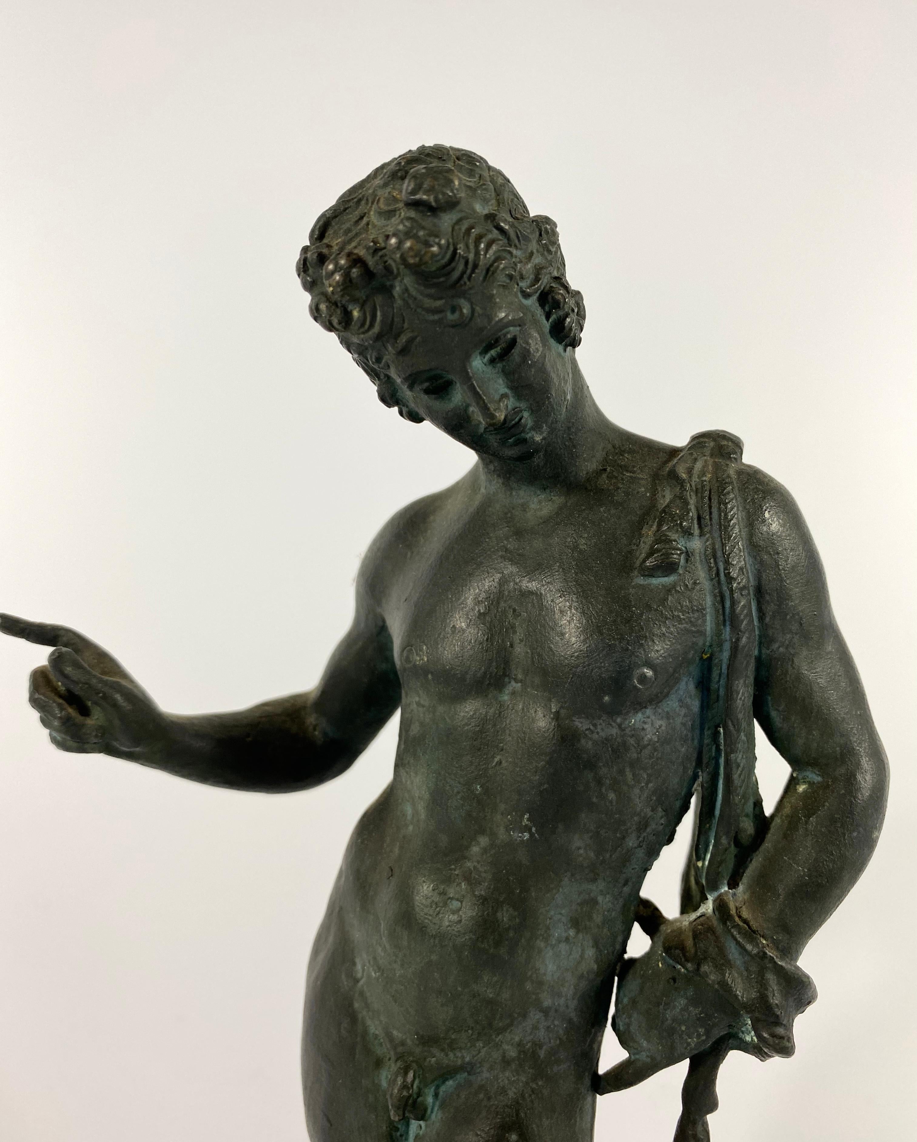 Italian ‘Grand Tour’ bronze figure of Narcissus, circa 1870. The naked youth captivated by his reflection in a pool of water. He wears a band of grape and vine, in his wavy hair, and a goat skin over his shoulder.
Set upon a circular base, cast