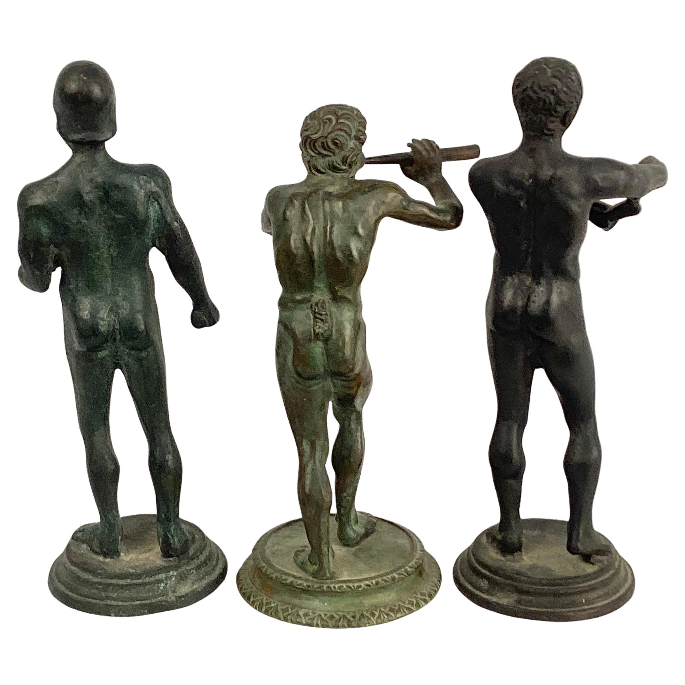 Grand Tour Estatuas de bronce de tres varones desnudos de la mitología, todos ellos en diversas posturas. La altura de estas pequeñas estatuas oscila entre 5,5