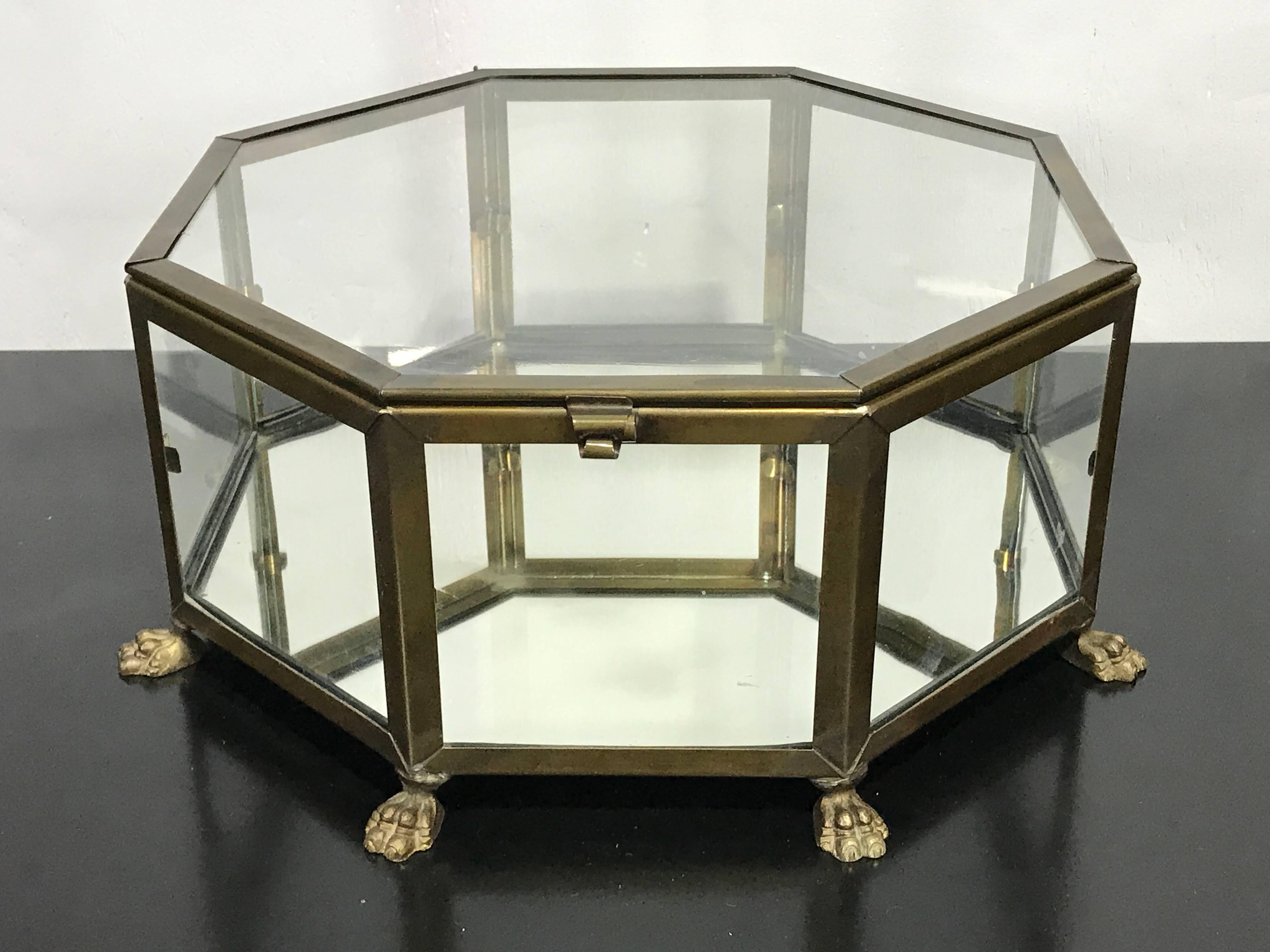 Italian grand tour style brass octagonal table vitrine, with lift top mirrored base raised on eight paw feet.