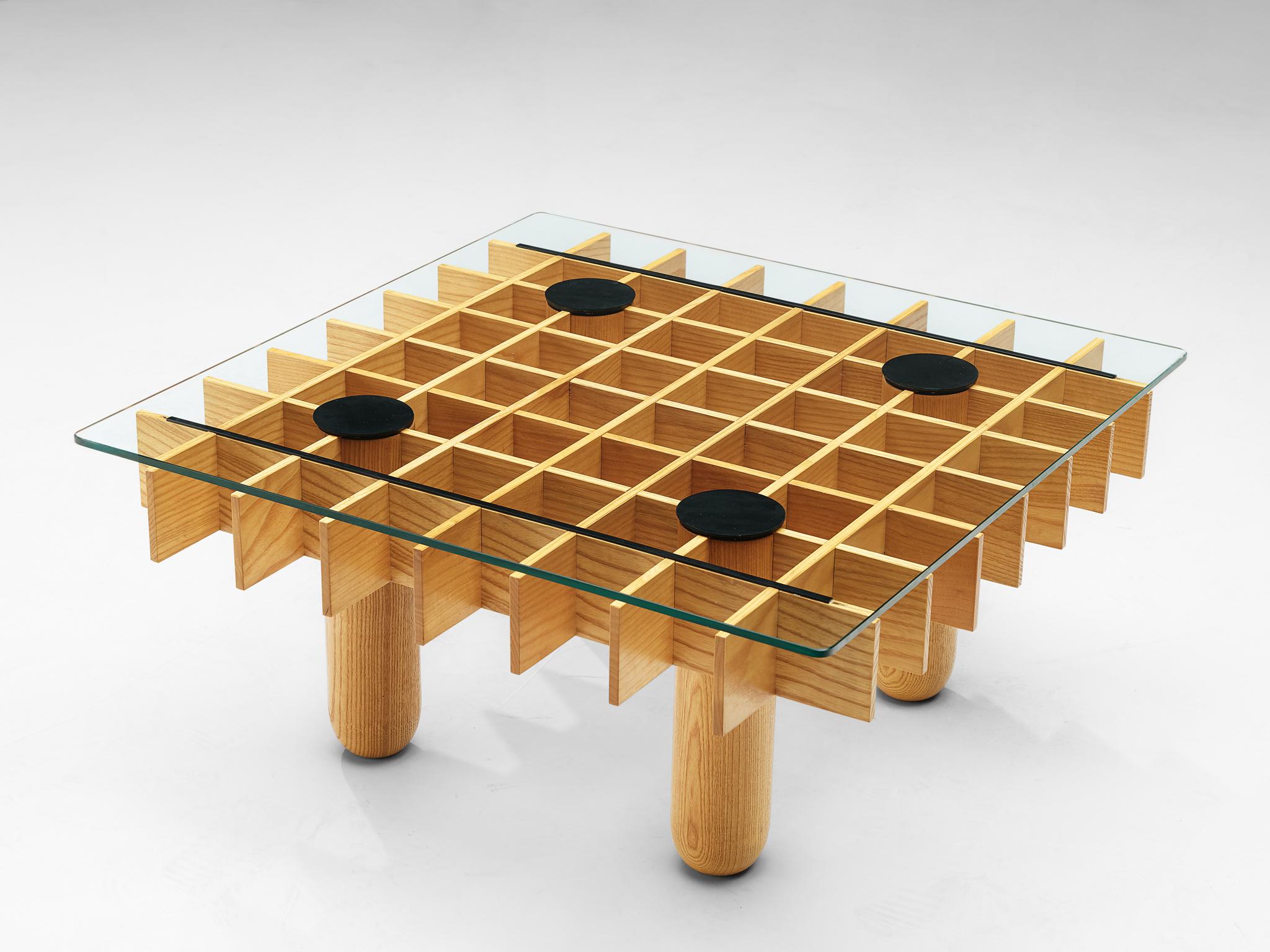 Coffee table, in maple and glass, Italy, 1974. 

This blond coffee table from Italy consists of a wooden grid, build up out of maple laths. Four solid round legs. On the grid rests a squire glass top. Black leather felts protect the glass and wood,