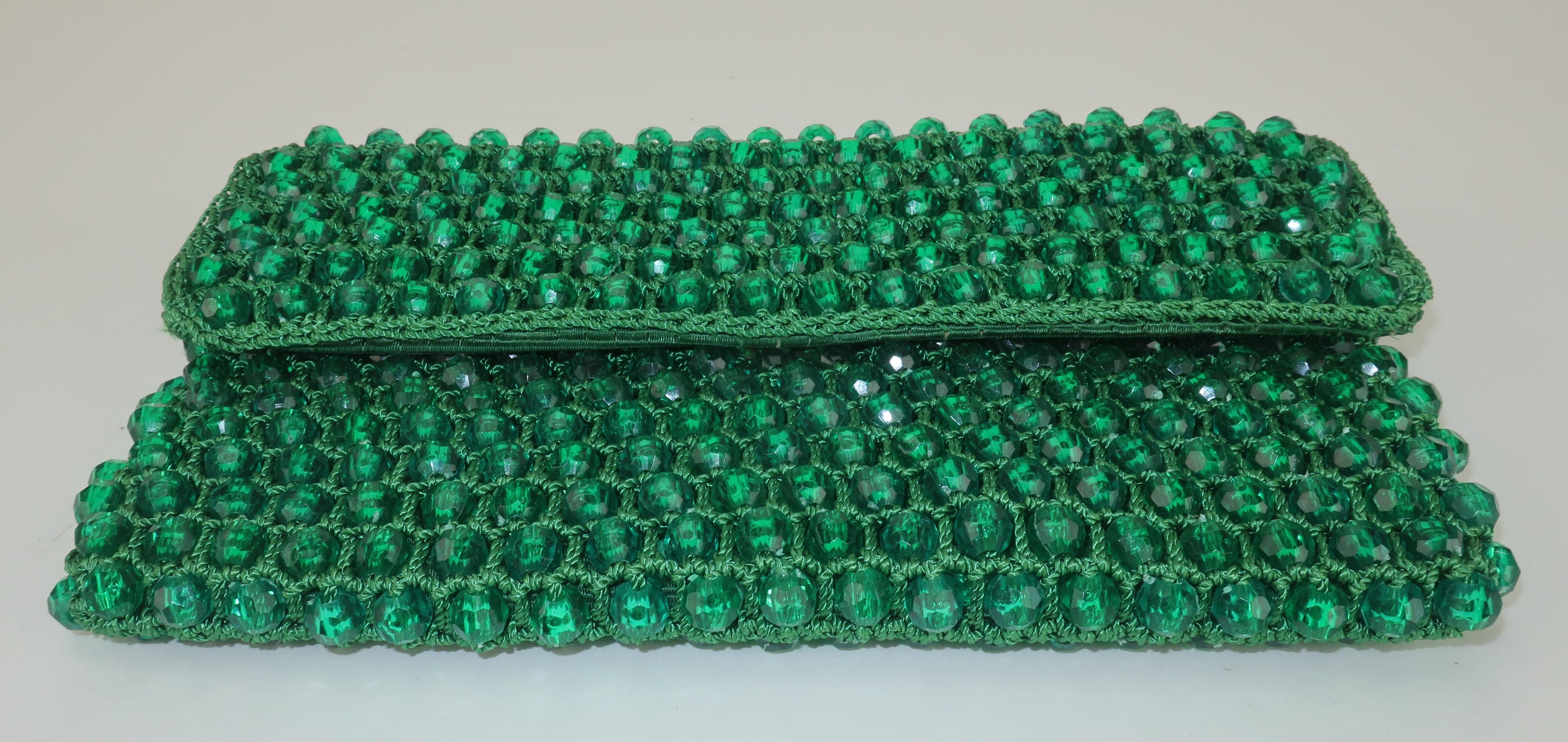 1950's Italian green beaded clutch handbag for Franklin Simon of New York.  The simple envelope silhouette is constructed of a silk crochet body embellished with faceted green translucent beading.  The snap closure opens to reveal a silk faille