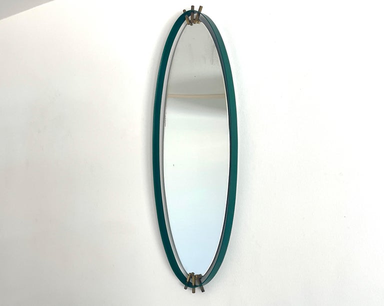 Chic 1950's Italian mirror with green enamel and brass accents. 