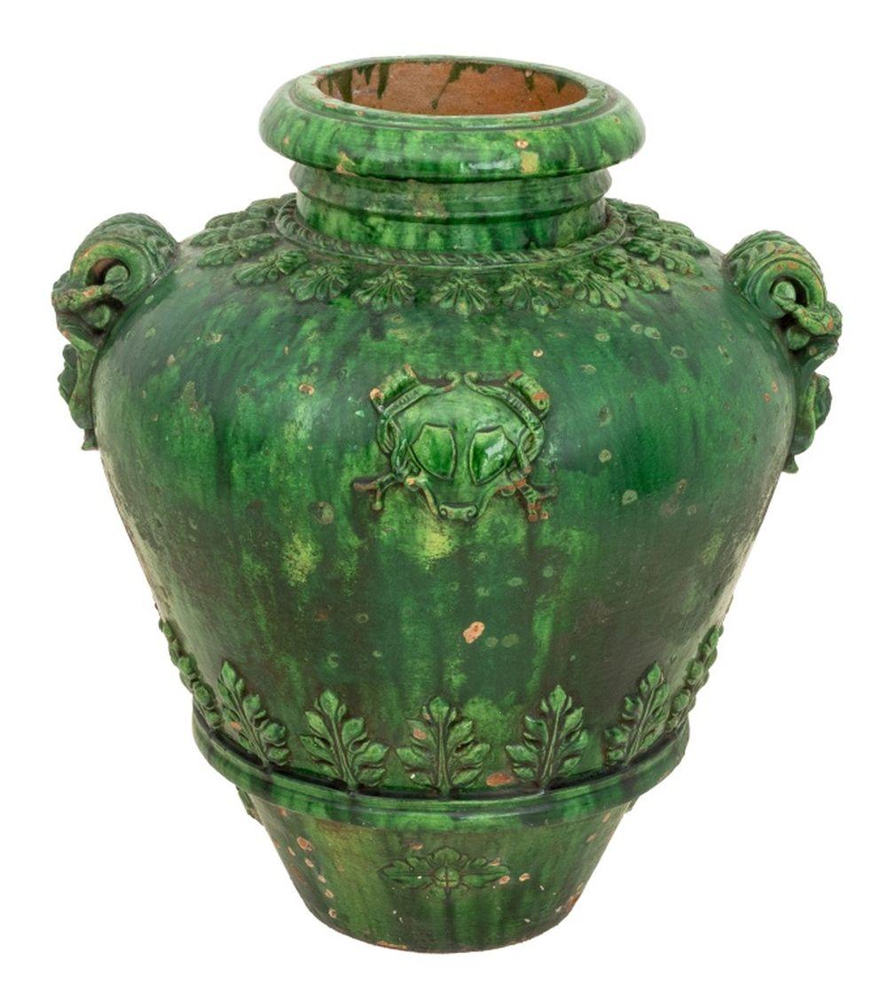 Vaso italiano in terracotta smaltata verde a due manici, XIX secolo. Il vaso a balaustro ha uno stemma applicato, manici a mascherina e decorazione fogliare. 27