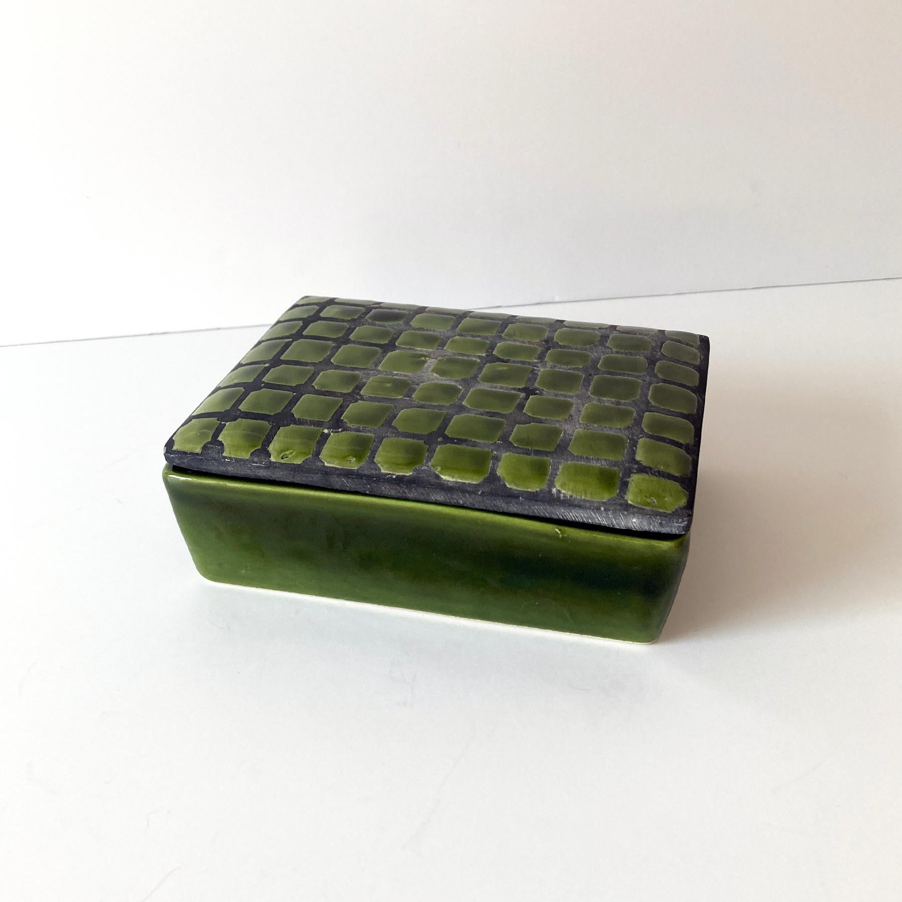 Bold green Italian ceramic lidded box. The stunning green shade contrasts beautifully with gray tone between the tile pattern. The size makes this piece versatile, as a jewelry box, or catchall. This box looks great as part of a group, or