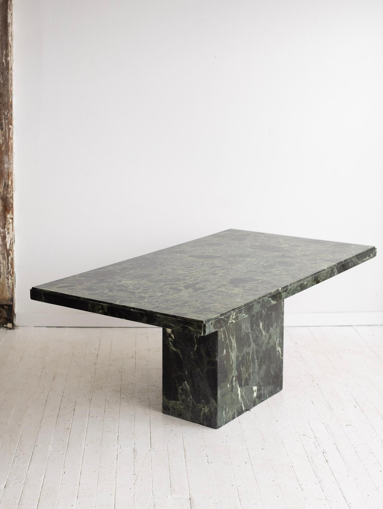 Italian green marble dining table. Solid marble top rests upon hollow marble pedestal base. A very heavy piece overall. Comfortably seats 4 to 6 people.