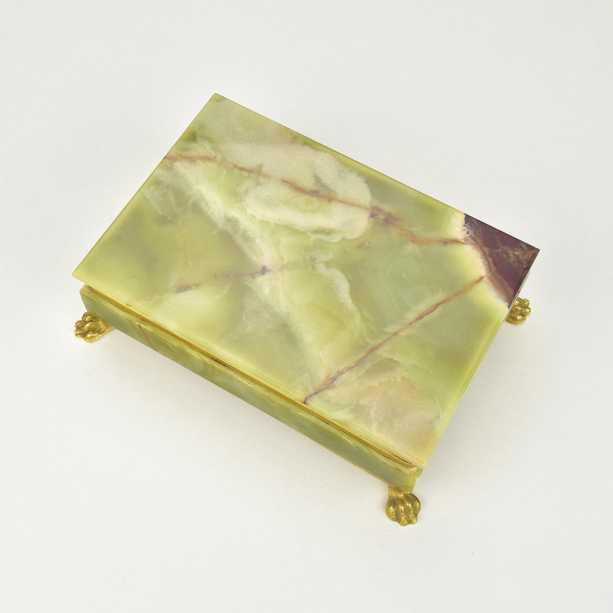 This Italian green onyx marble jewelry box features an elegant and luxurious design. Crafted from rich green onyx stone, the box is adorned with intricately detailed lion feet, adding a regal and timeless touch. The smooth, polished surface of the