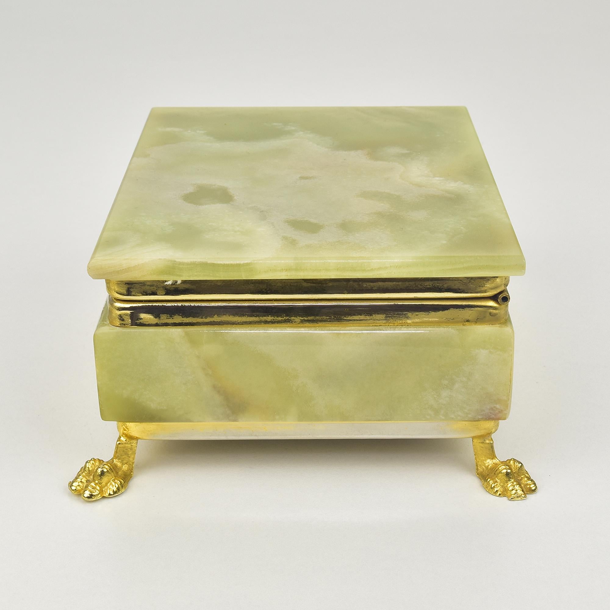 This Italian green onyx marble jewelry box features an elegant and luxurious design. Crafted from rich green onyx stone, the box is adorned with intricately detailed lion feet, adding a regal and timeless touch. The smooth, polished surface of the