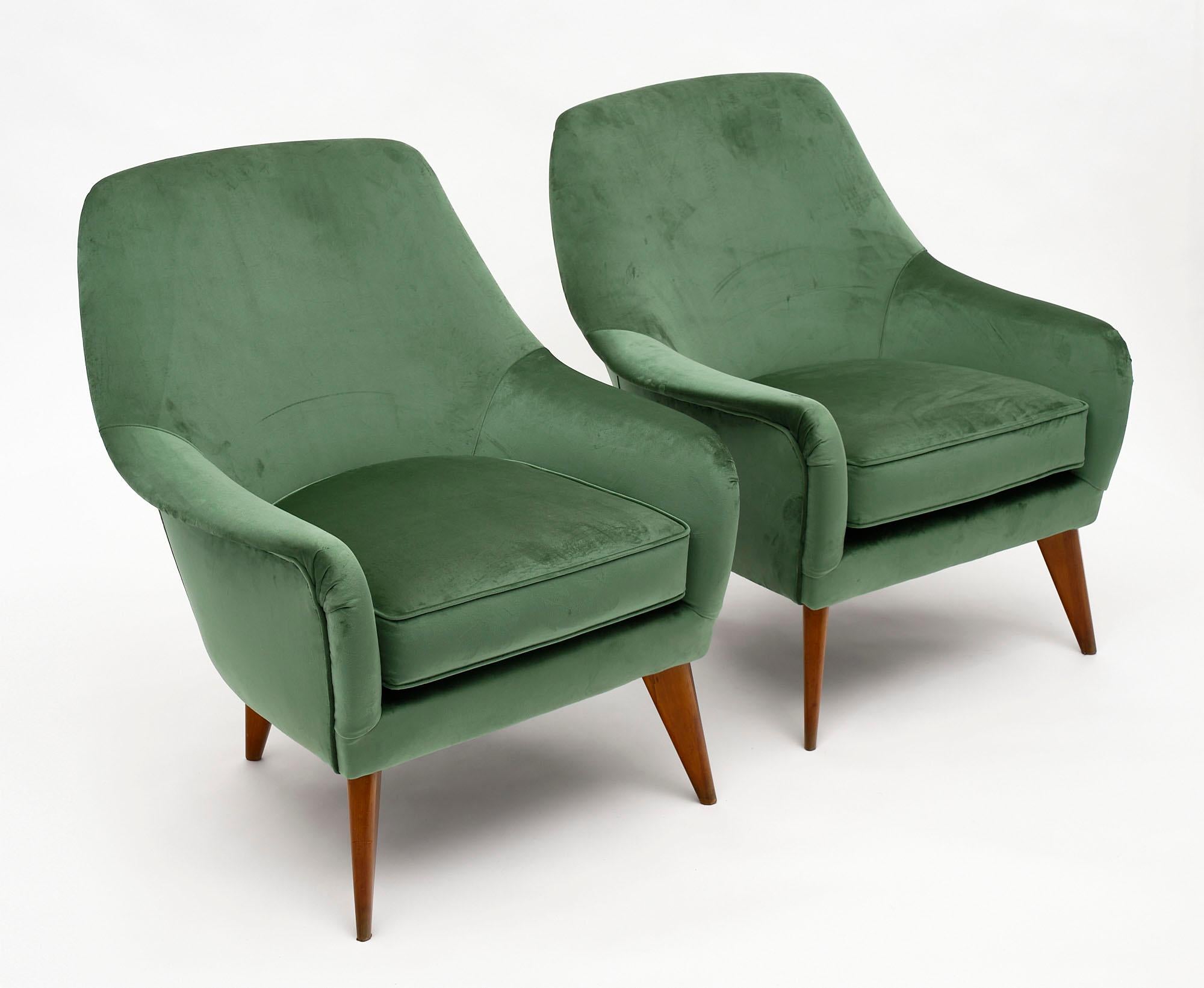 Pair of Italian green velvet armchairs from Verona. This comfortable pair has been newly upholstered in a soft velvet. We love the solid wood frame with flared cherry wood legs.