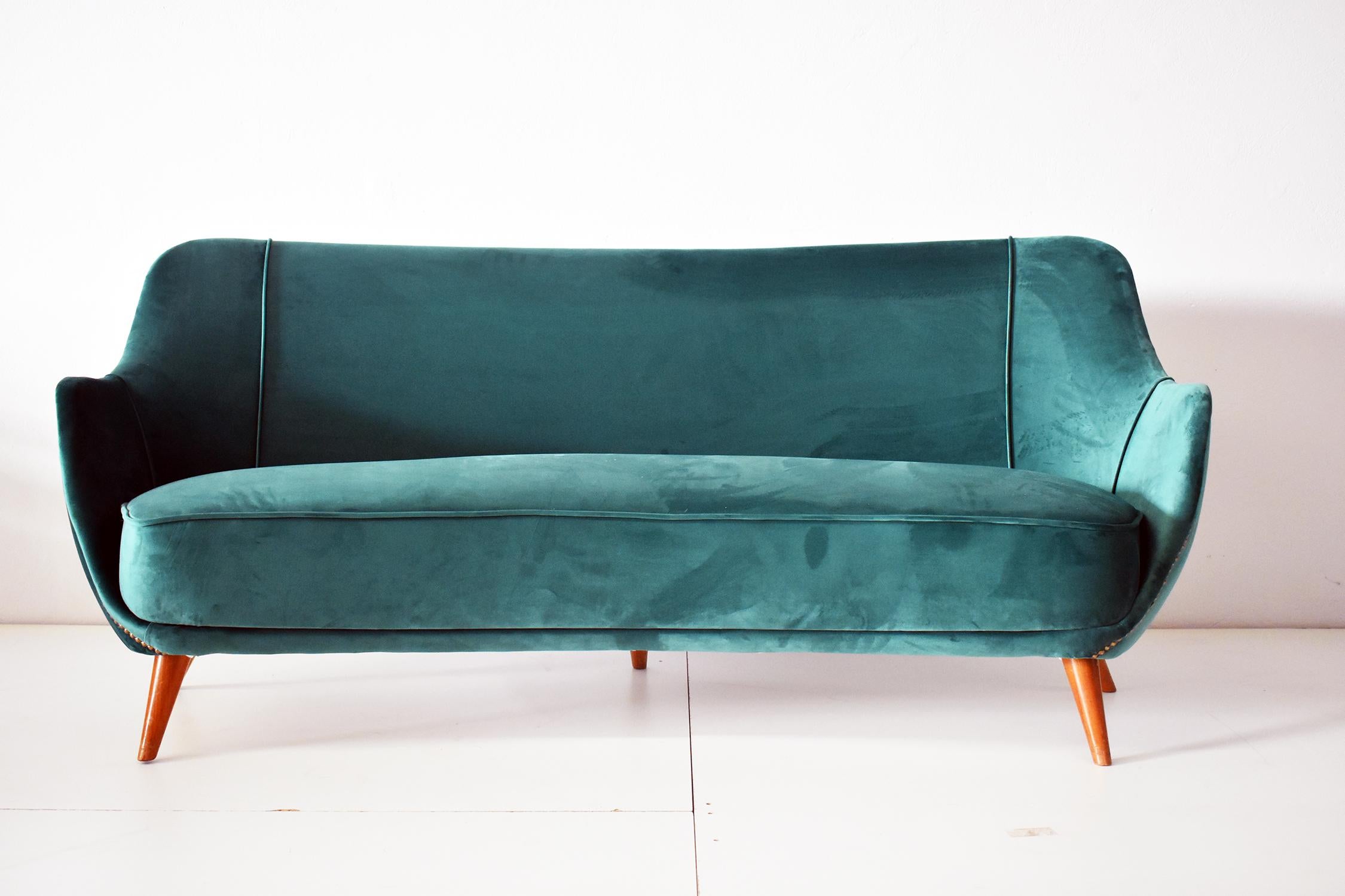 Italian green velvet, wood and brass sofa, 1950s.
The sofa has a wooden structure with forest green velvet upholstery, on the profiles there are brass buttons.