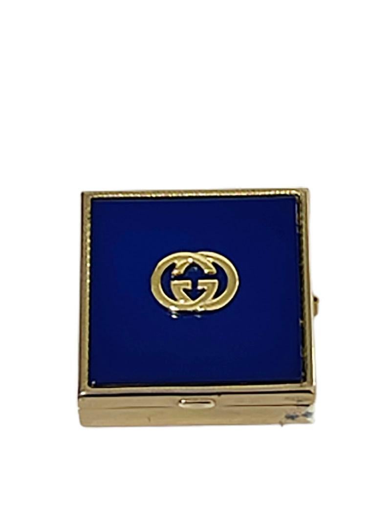 Italian Gucci small square pill box

A small square brass pill box with enamel and gold looks.
With logo of Gucci raised on the lid.
The mark of Gucci is in the inner lid.
It has a sliding lock at the side.
The pill or small sweets box is