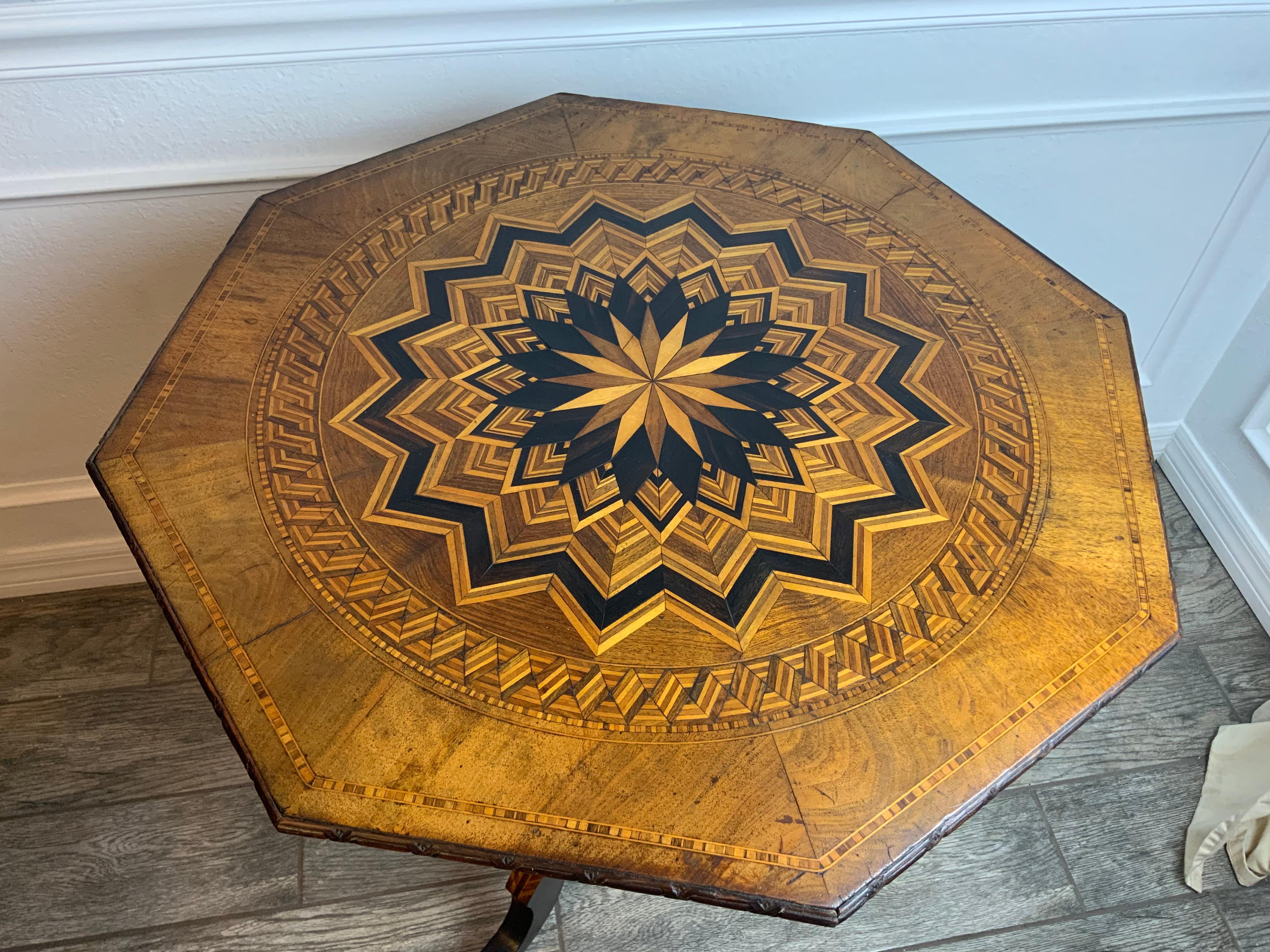 An exceptionally nice Walnut octagon marquetry tripod table. The Marquetry design on the top, base, and legs are constructed of mixed hardwoods.  The original surface has a great aged color and patina and is in very good condition.  The legs, base,