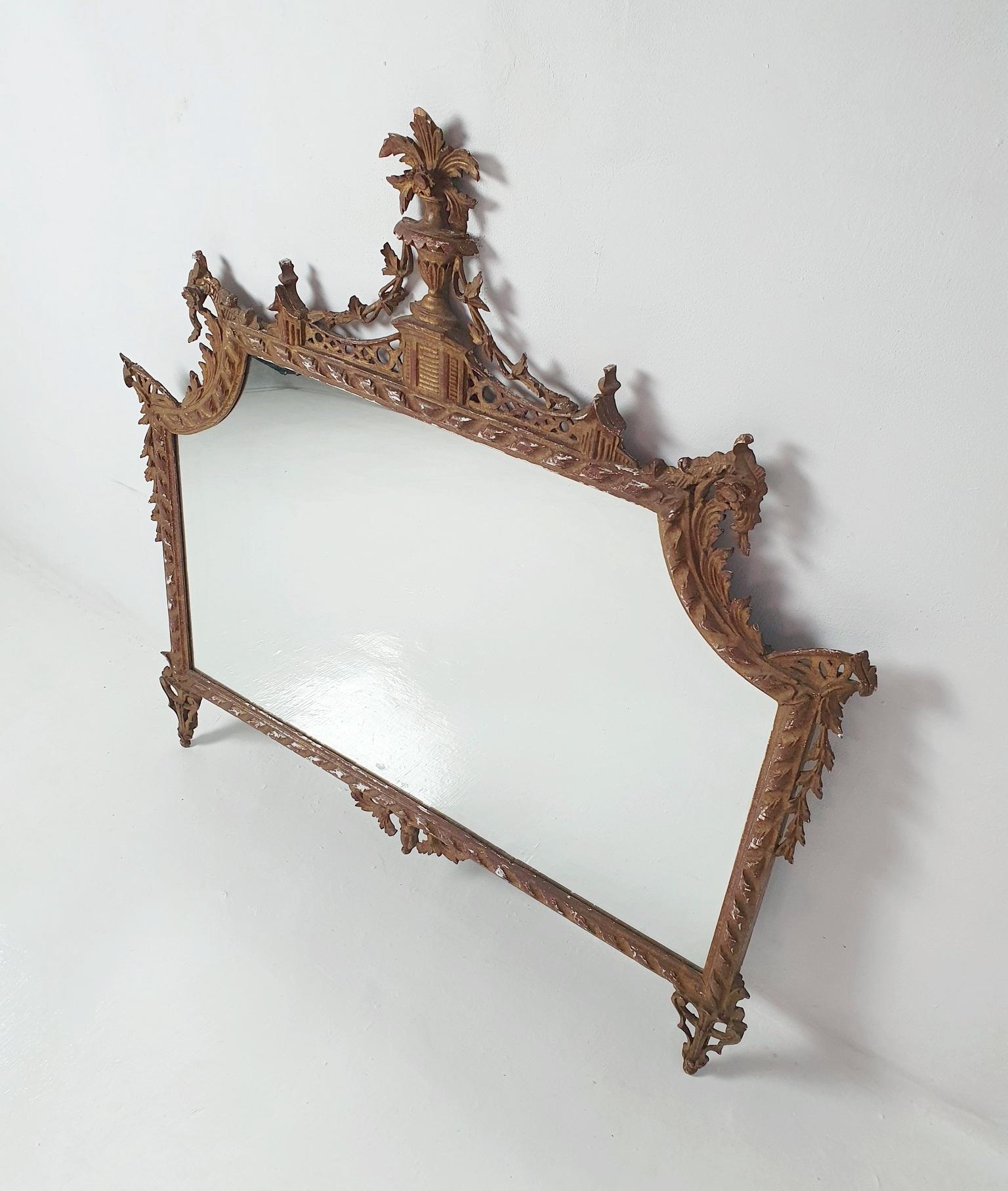 An Italian reproduction hand carved gorgeous overmantle mirror representing a delicate style of the second half of the 1700's. The mirror is made entirely from wood, stucco and guilded. The gold is worn in places only adding to it's charm. Overall