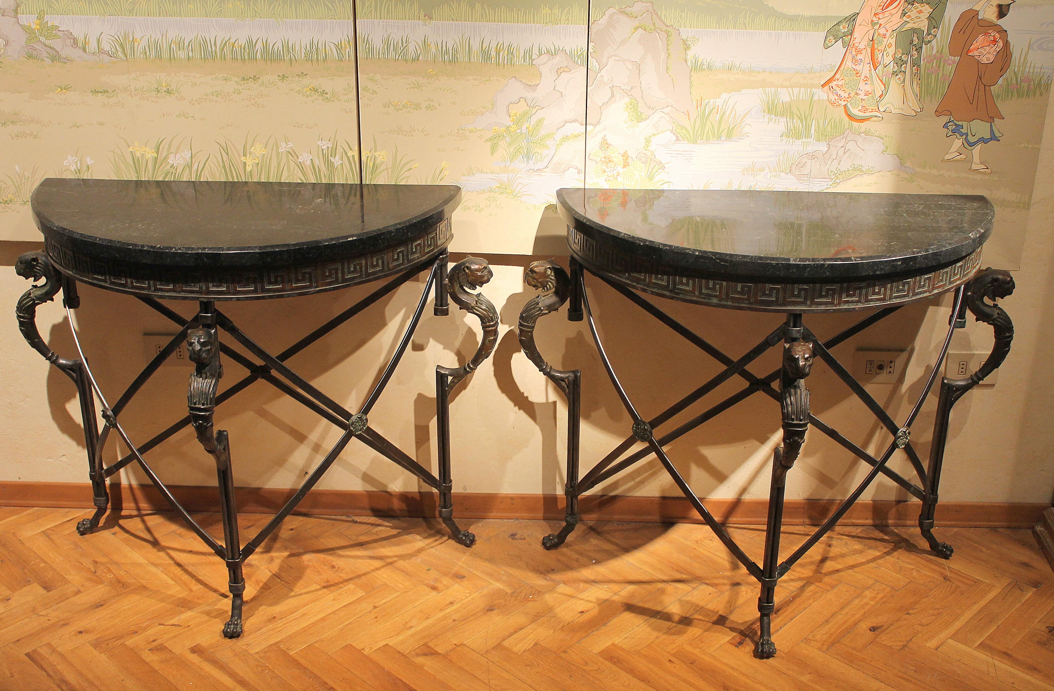 This early 20th century chic pair of Italian half moon design console tables are very interesting, extremely detailed and well proportioned.
The X-shaped stretcher structure is made of wrought iron, three casted bronze griffin decorations are