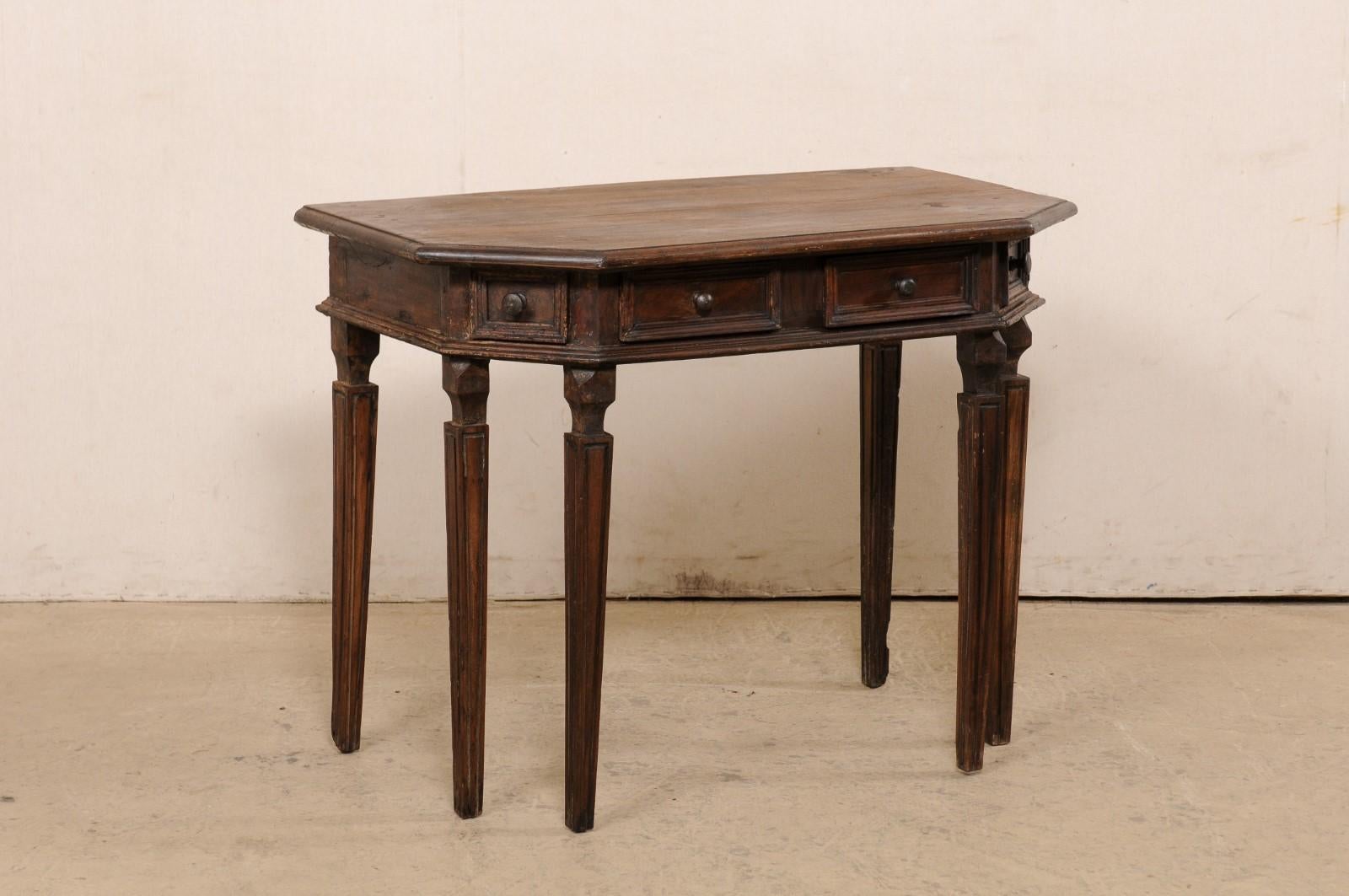 An Italian carved walnut demi console with drawers from the 18th century. This antique table from Italy has a halved-octagon shaped top (comprised of a single board) which slightly overhangs the apron below that houses a pair of small recessed-panel